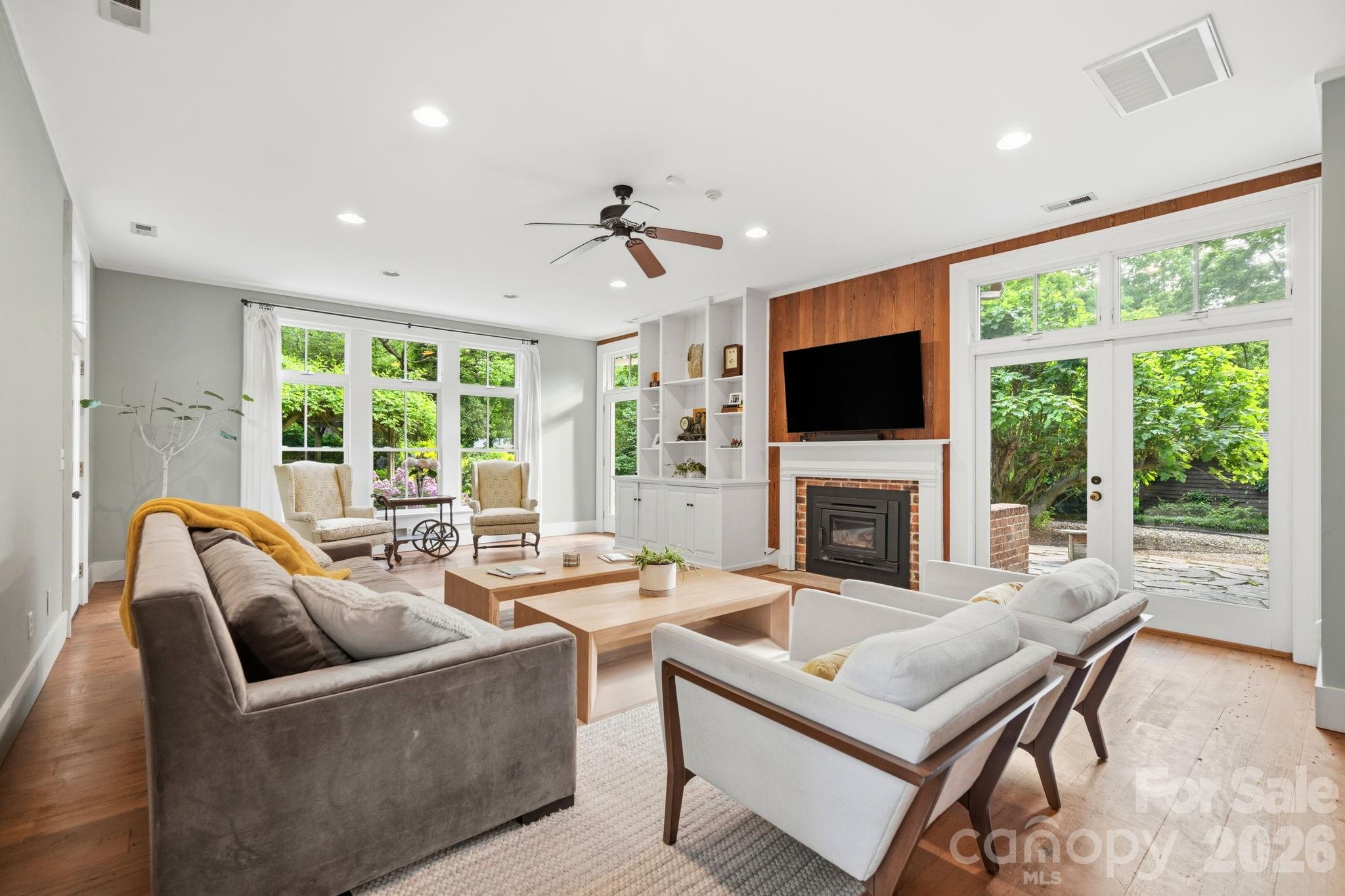 Great room addition by previous owners offer wall of windows and glass doors, natural wood accent wall and built-in book cases and cabinets, separate H/A. - 10915 Beatties Ford Road, Huntersville