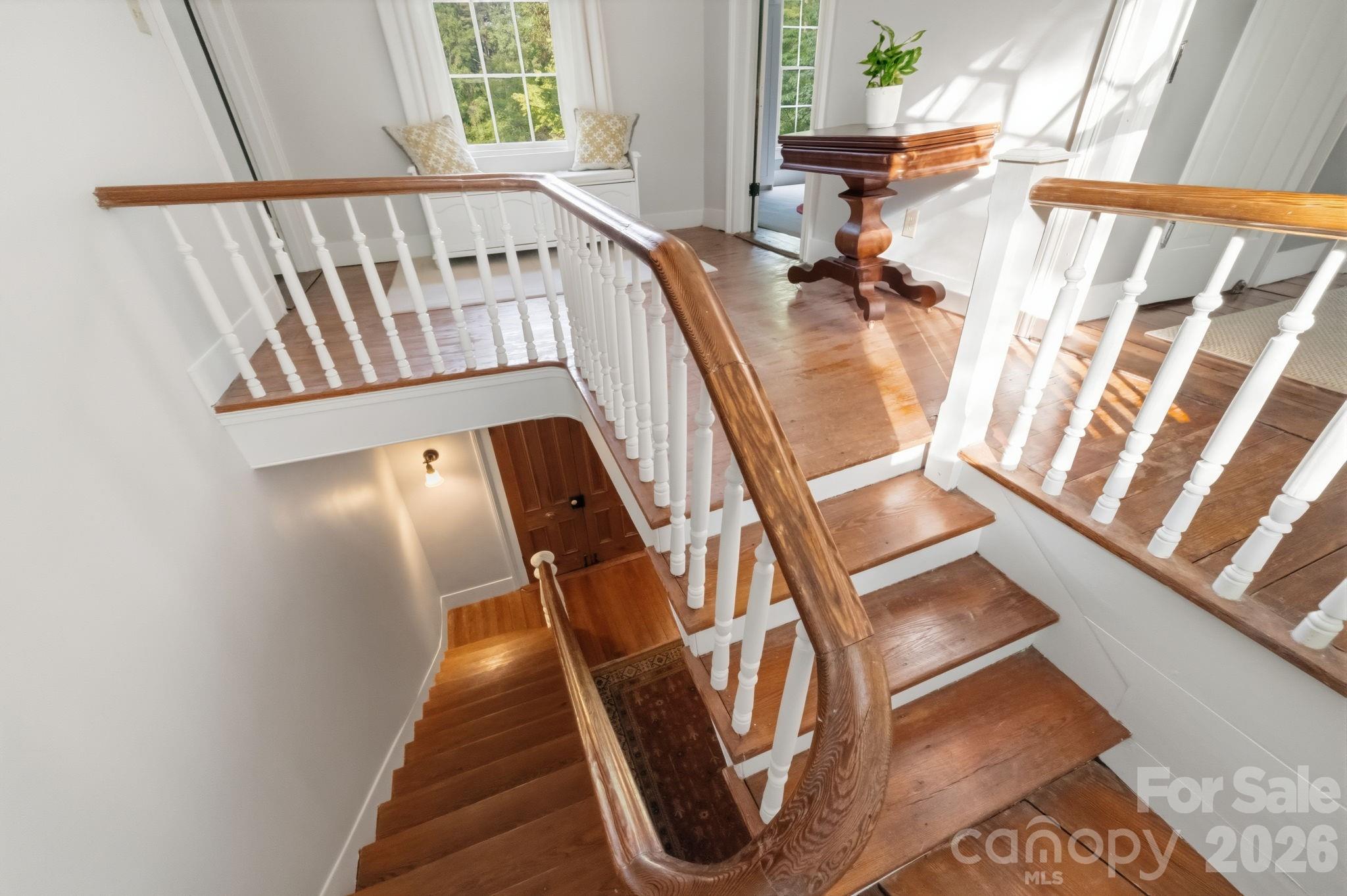 The original stairs winding switchback design, original wood treads, painted balusters, curved plaster walls, and substantial handrail. - 10915 Beatties Ford Road, Huntersville