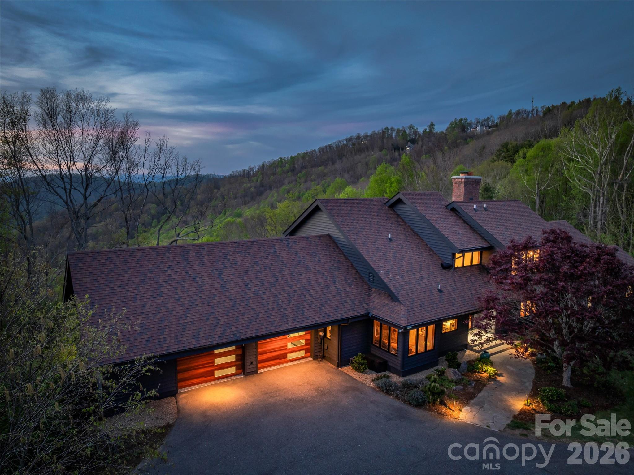 Estate driveway leads to oversized two car garage with EV charging. Newly installed insulated steel garage doors feature stylish Midcentury modern wood appearance facades. - 100 Big Spring Drive, Asheville