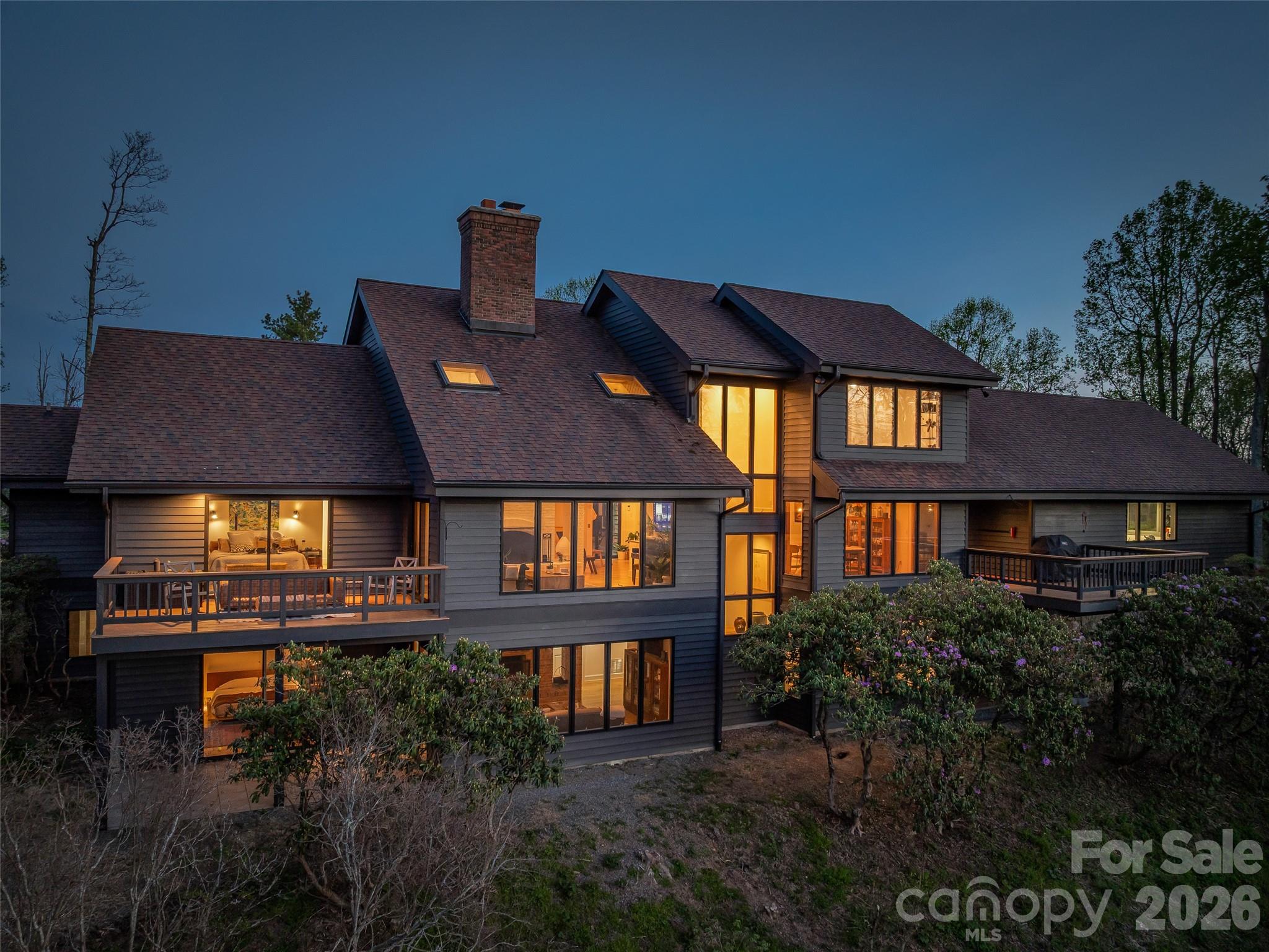 Walls of windows and well-appointed decks allow for expansive sunset views of the Beaverdam valley and beyond. - 100 Big Spring Drive, Asheville