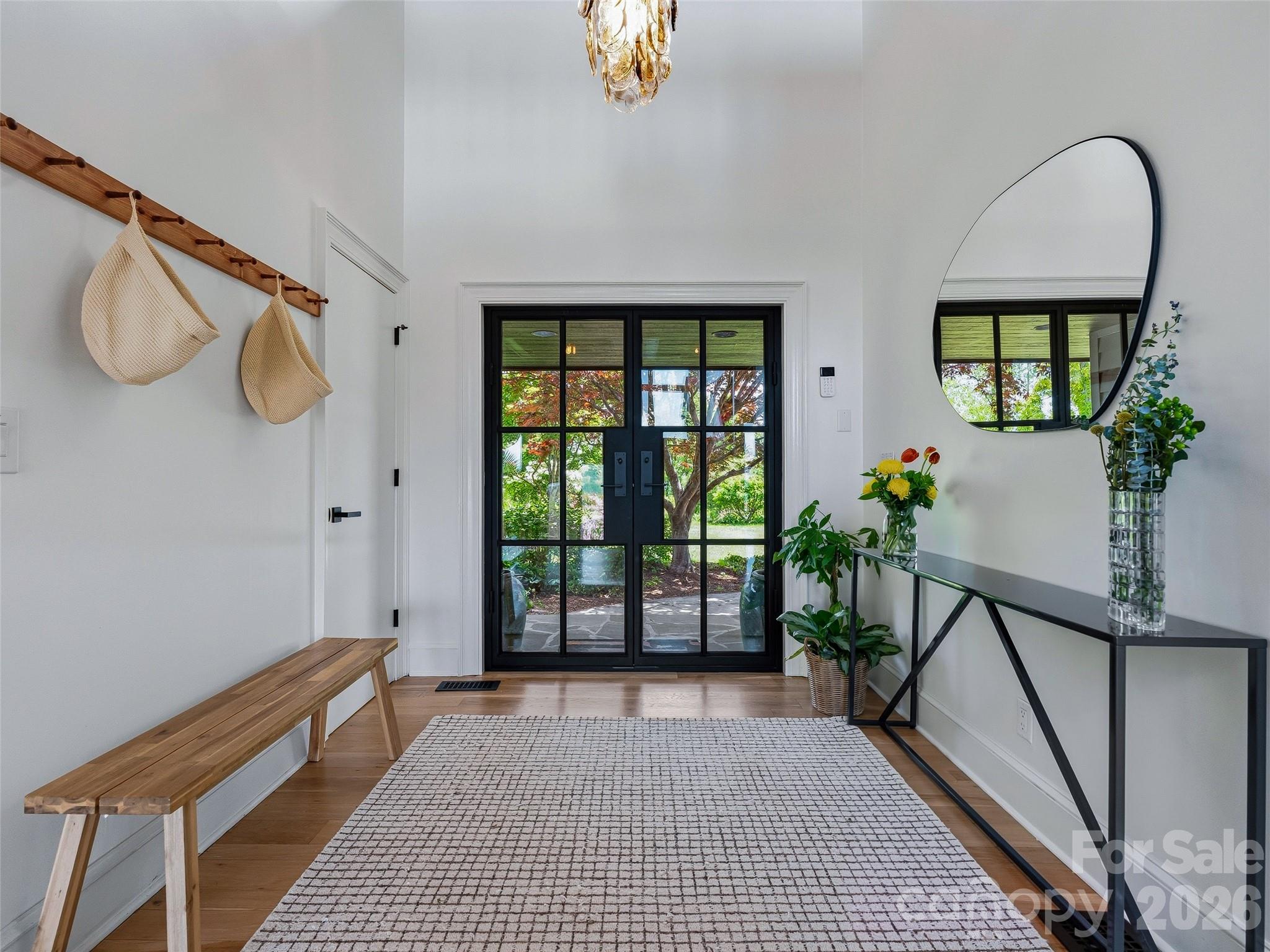 The foyer sets an elegant tone with two-story ceilings and an original Murano Italian vintage glass chandelier. - 100 Big Spring Drive, Asheville