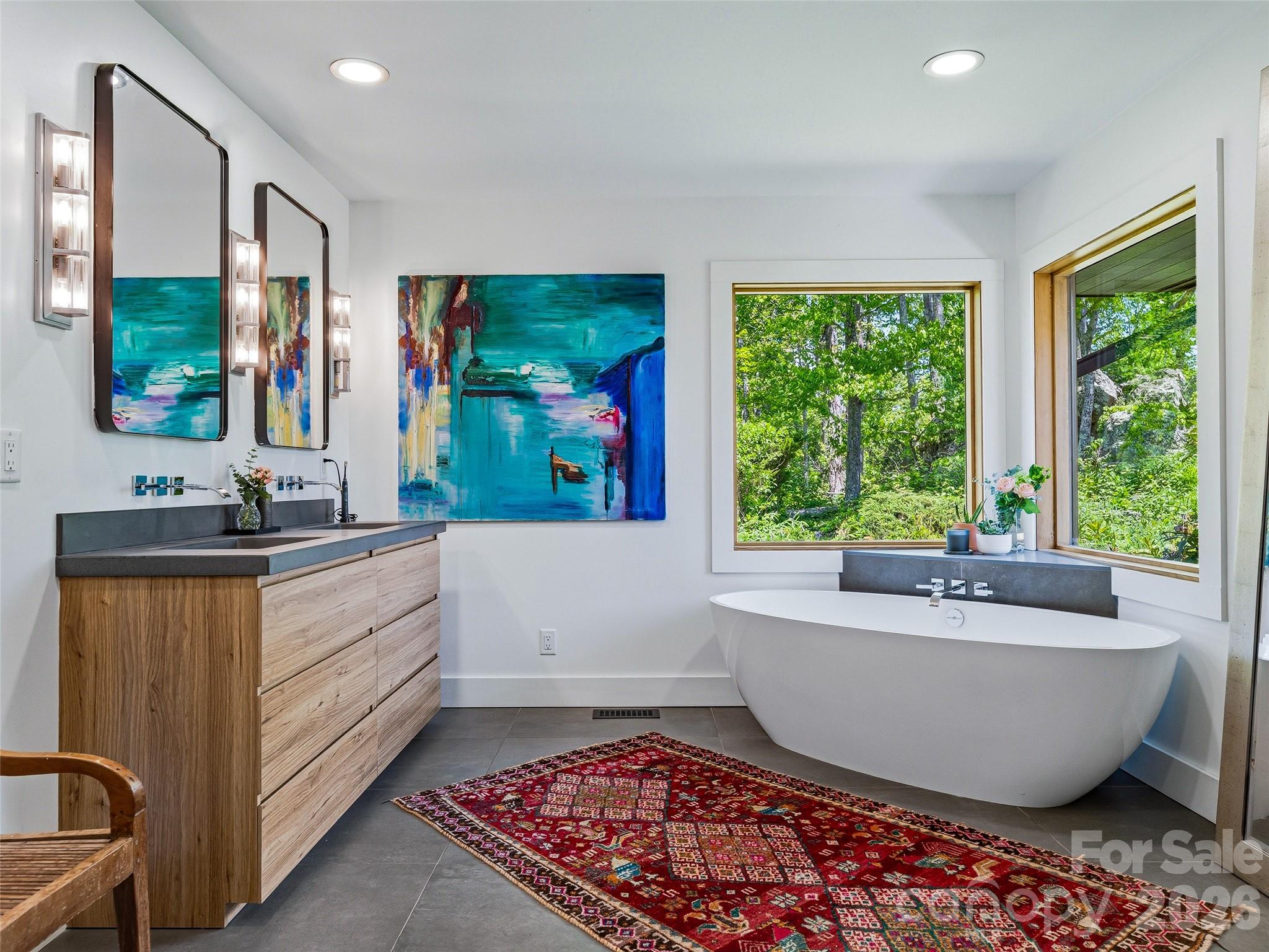 Primary suite bathroom featuring Victoria + Albert soaking tub with picture windows framing mountain views. - 100 Big Spring Drive, Asheville