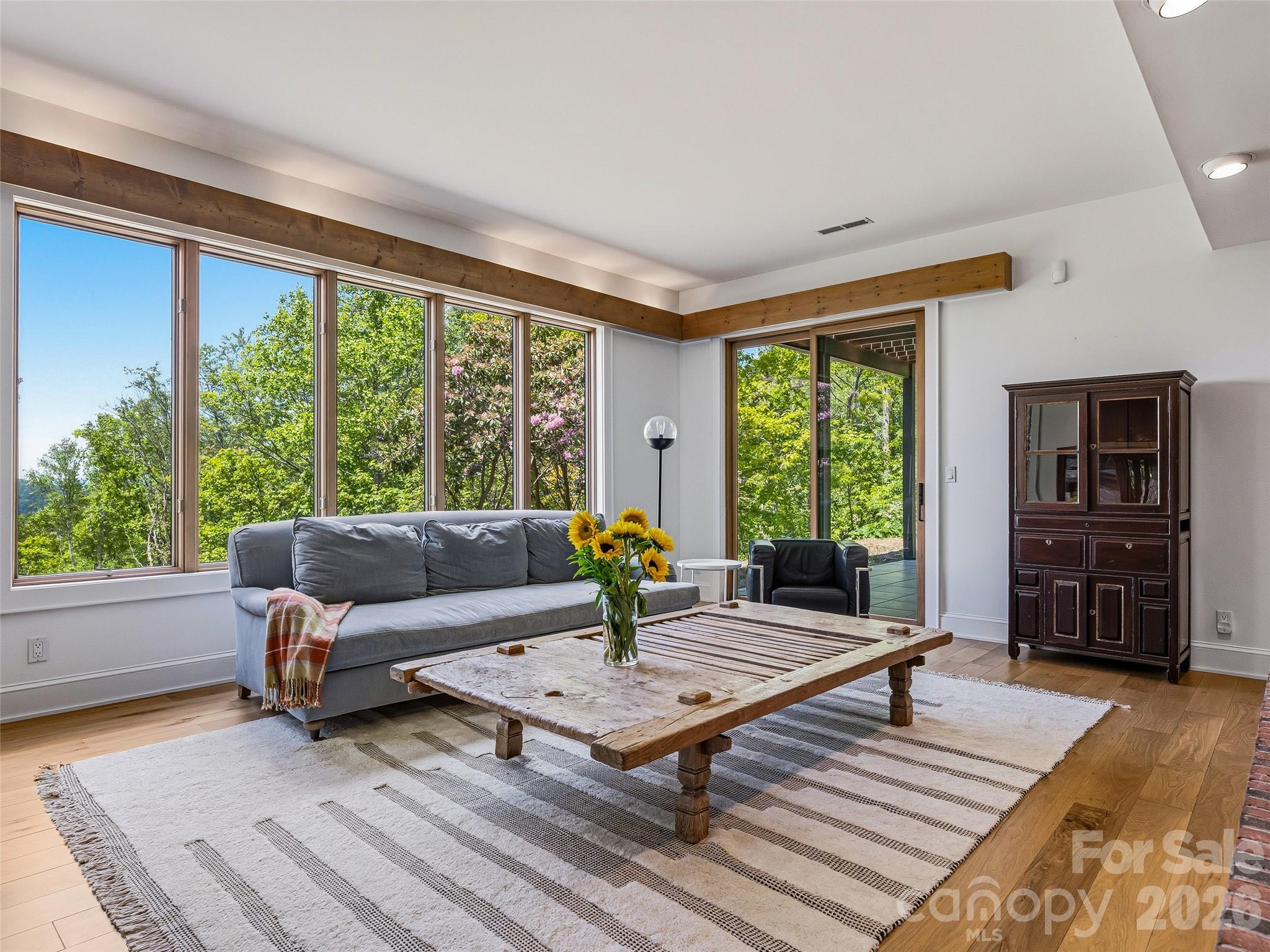 A second great room on the lower floor features more large windows framing finite mountain views. - 100 Big Spring Drive, Asheville