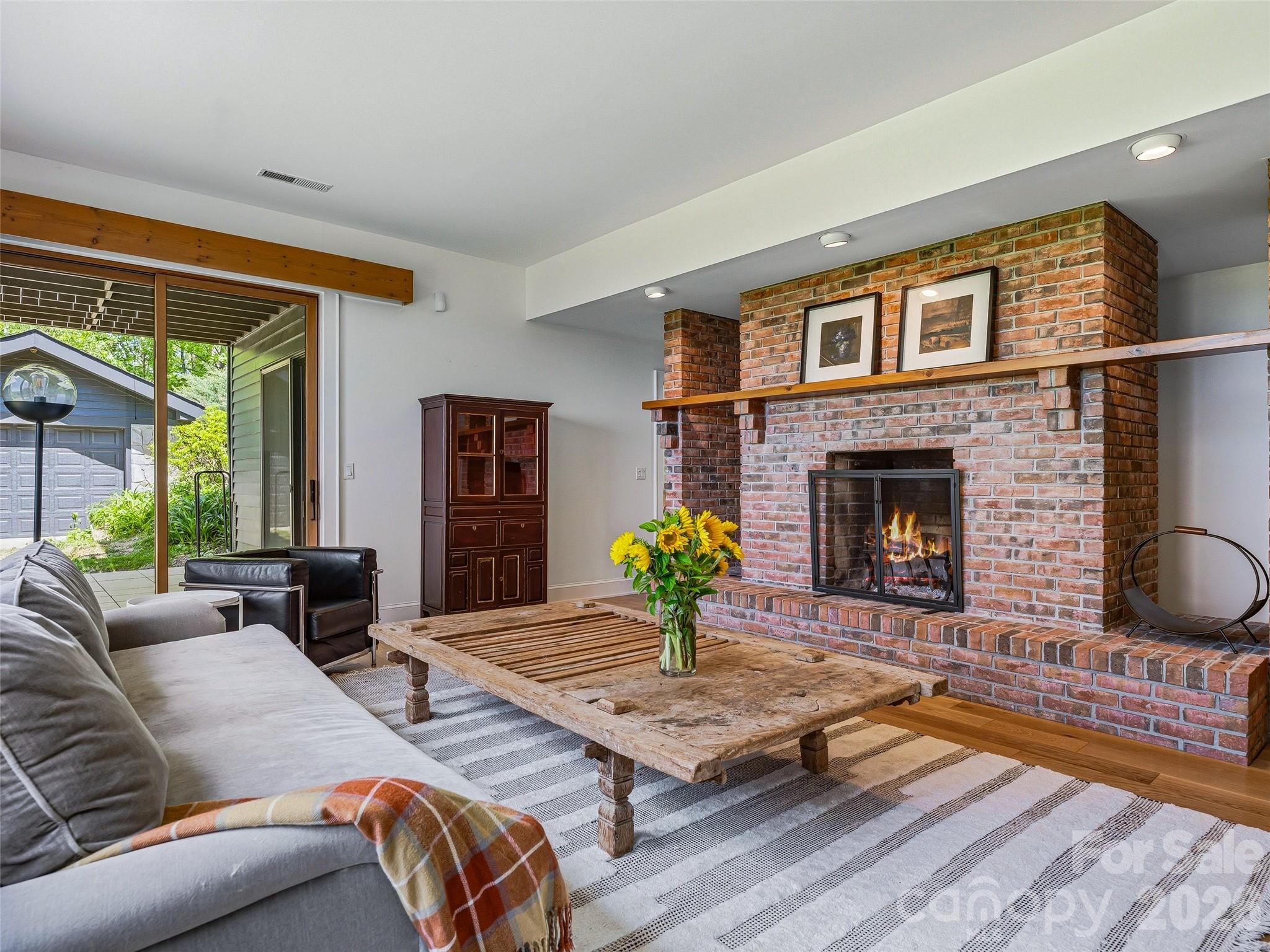This cozy room also includes a second wood burning fireplace with wood storage niches and a wooden mantel. - 100 Big Spring Drive, Asheville
