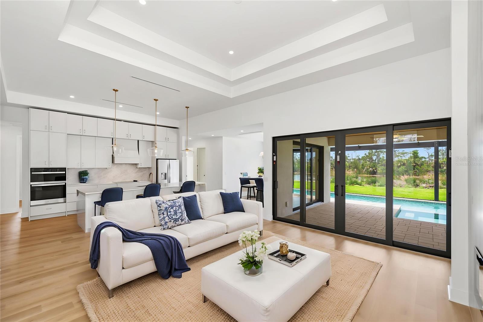 Virtually Staged Living Room Showcasing Tray Ceilings and Seamless indoor-Outdoor Living. - 16692 LIGGETT CIR, PORT CHARLOTTE