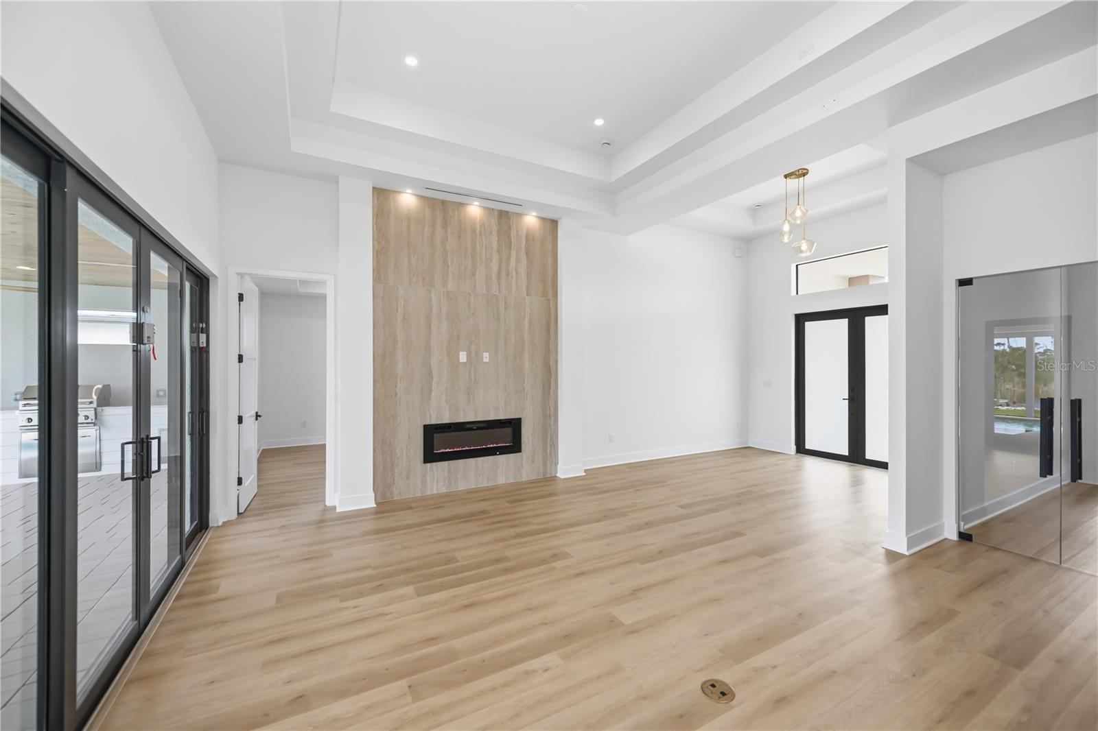 Grand Living Room with Marble Accent Wall and Linear Fireplace. - 16692 LIGGETT CIR, PORT CHARLOTTE