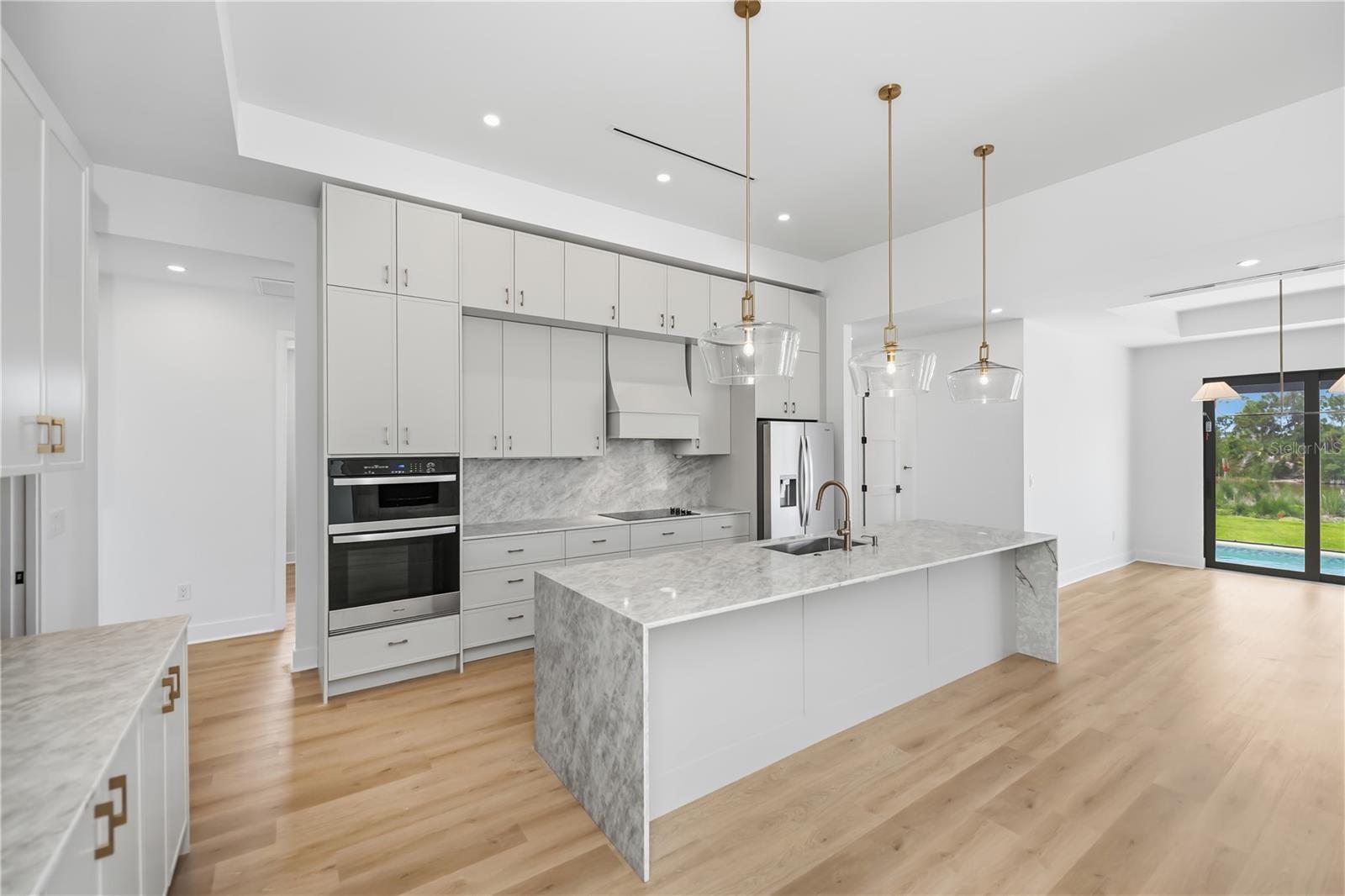 Chef's Kitchen with Quartz Waterfall Island and Custom Cabinetry. - 16692 LIGGETT CIR, PORT CHARLOTTE