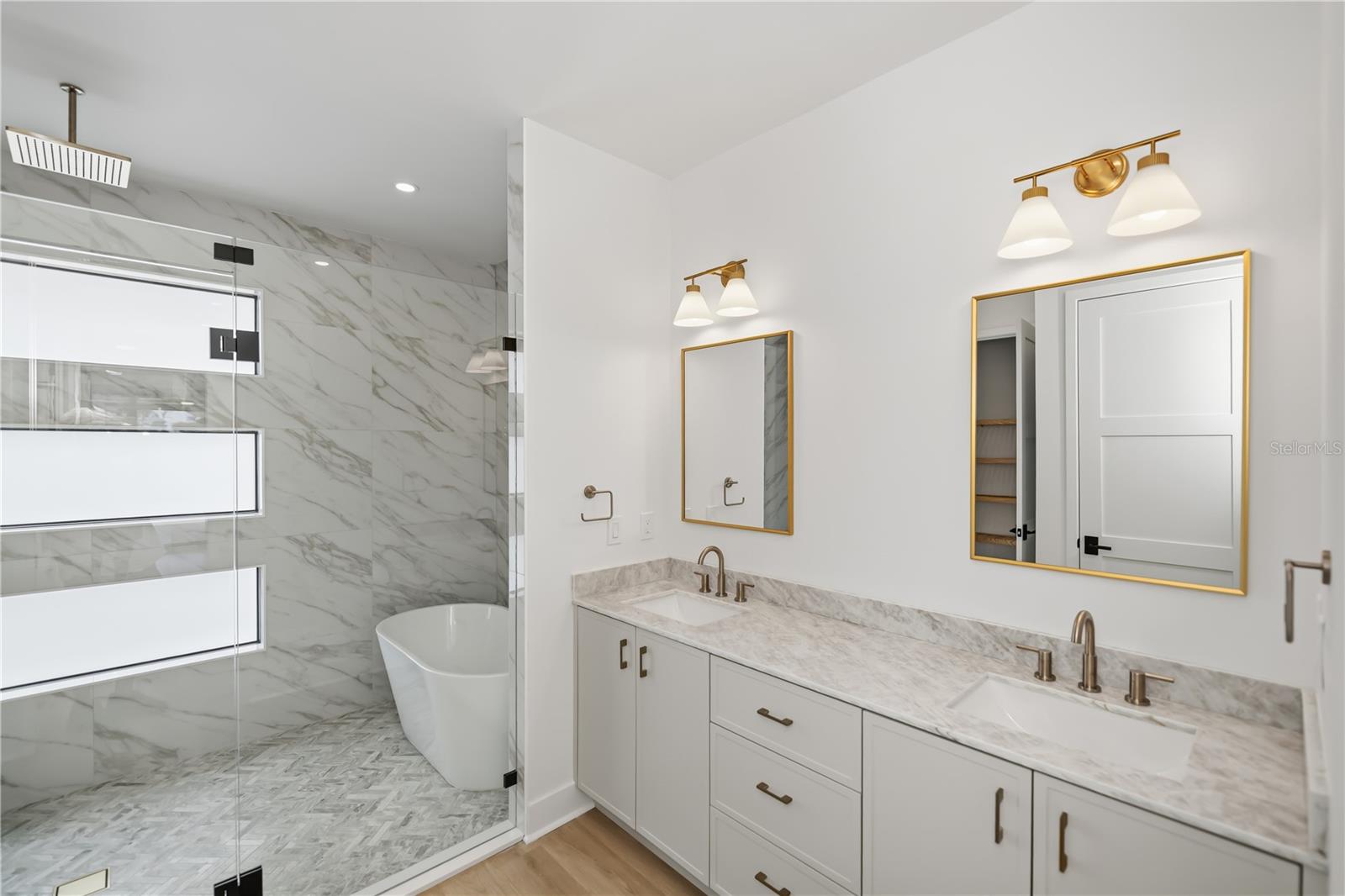 Spa-Inspired Primary Ensuite Featuring Dual Vanities, Soaking Tub, and Glass-Enclosed Walk-In Shower. - 16692 LIGGETT CIR, PORT CHARLOTTE