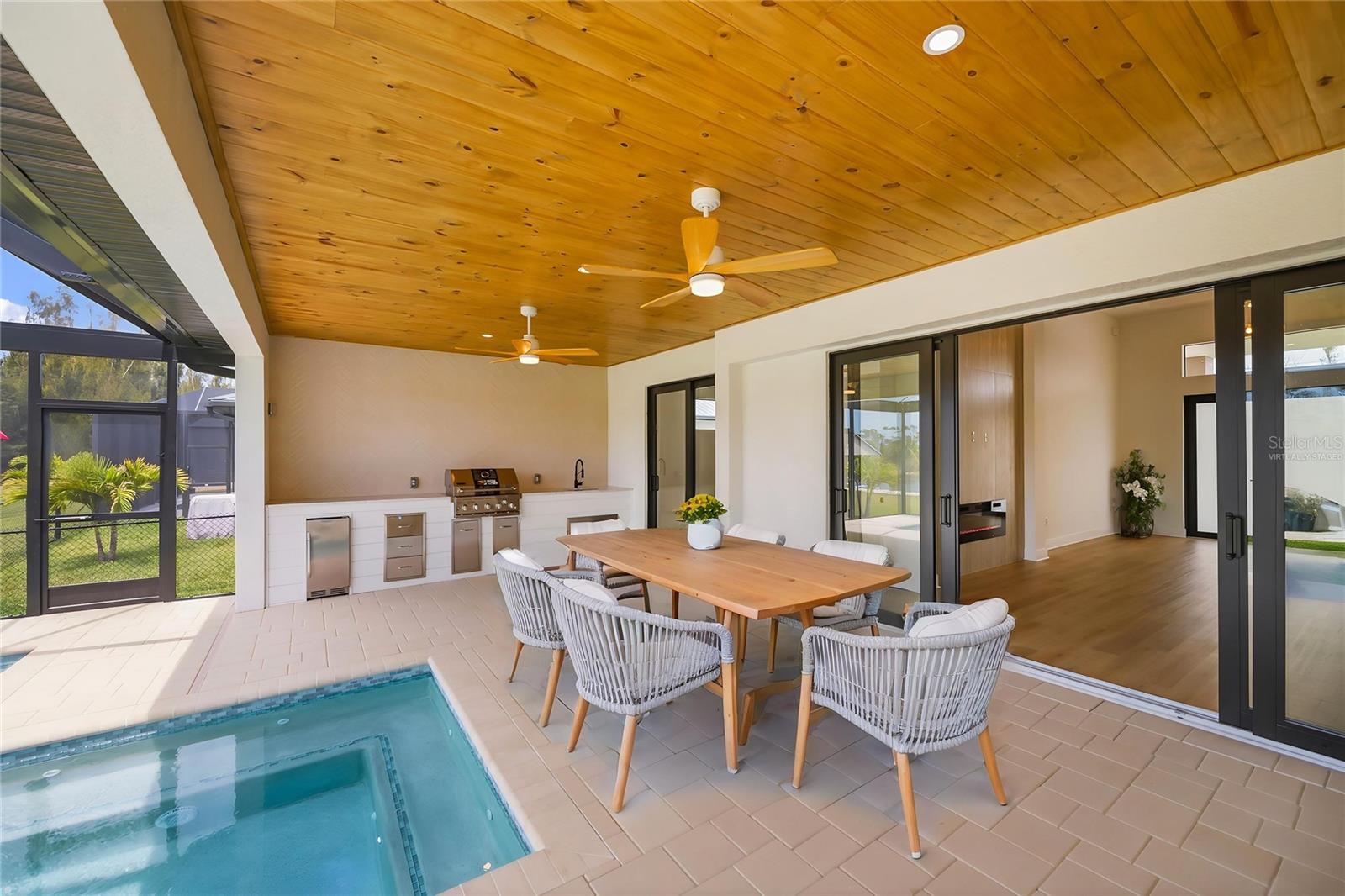 Virtually Staged Covered Lanai with Outdoor Kitchen and Poolside Dining. - 16692 LIGGETT CIR, PORT CHARLOTTE