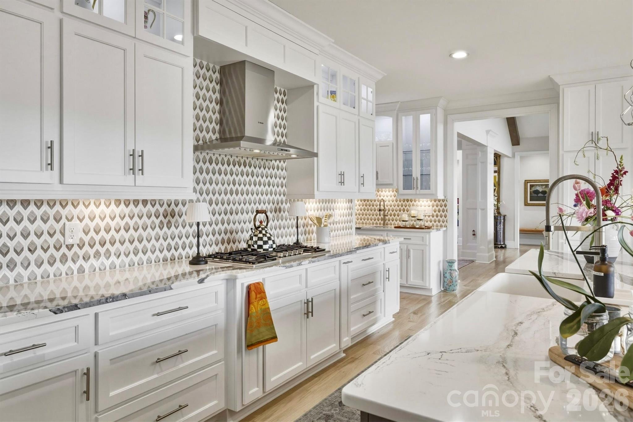 The stunning gourmet kitchen is designed for both everyday living and effortless entertaining.Featuring an elegant BLANCO farm sink, premium Bosch appliances, and luxurious Cambria Quartz countertops with coordinating unique tile backsplash. throughout the expansive island, generous work surfaces, and dedicated wet bar area. Lighted upper cabinets with glass doors showcase decorative items or fine china. - 1506 High Valley Way, Lenoir