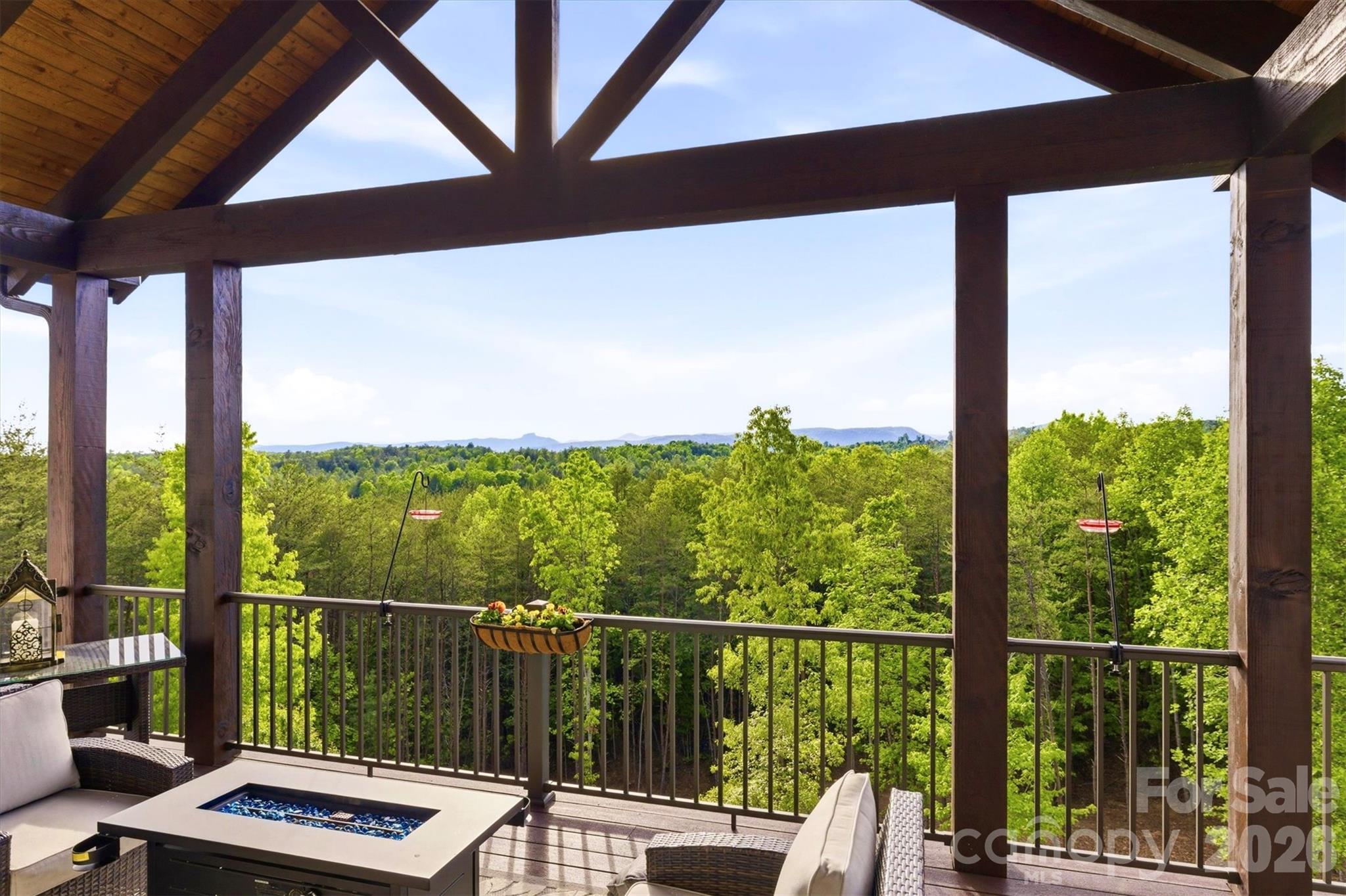 Experience seamless indoor-outdoor living and more highland panorama from the expansive, 14 ft deep, main level open air deck, screened porch, and covered porch. The porches' vaulted tongue-and-groove wood ceilings, durable Fiberon composite flooring, and commanding structural beams elevate the spaces and ensure 4 season enjoyment. - 1506 High Valley Way, Lenoir