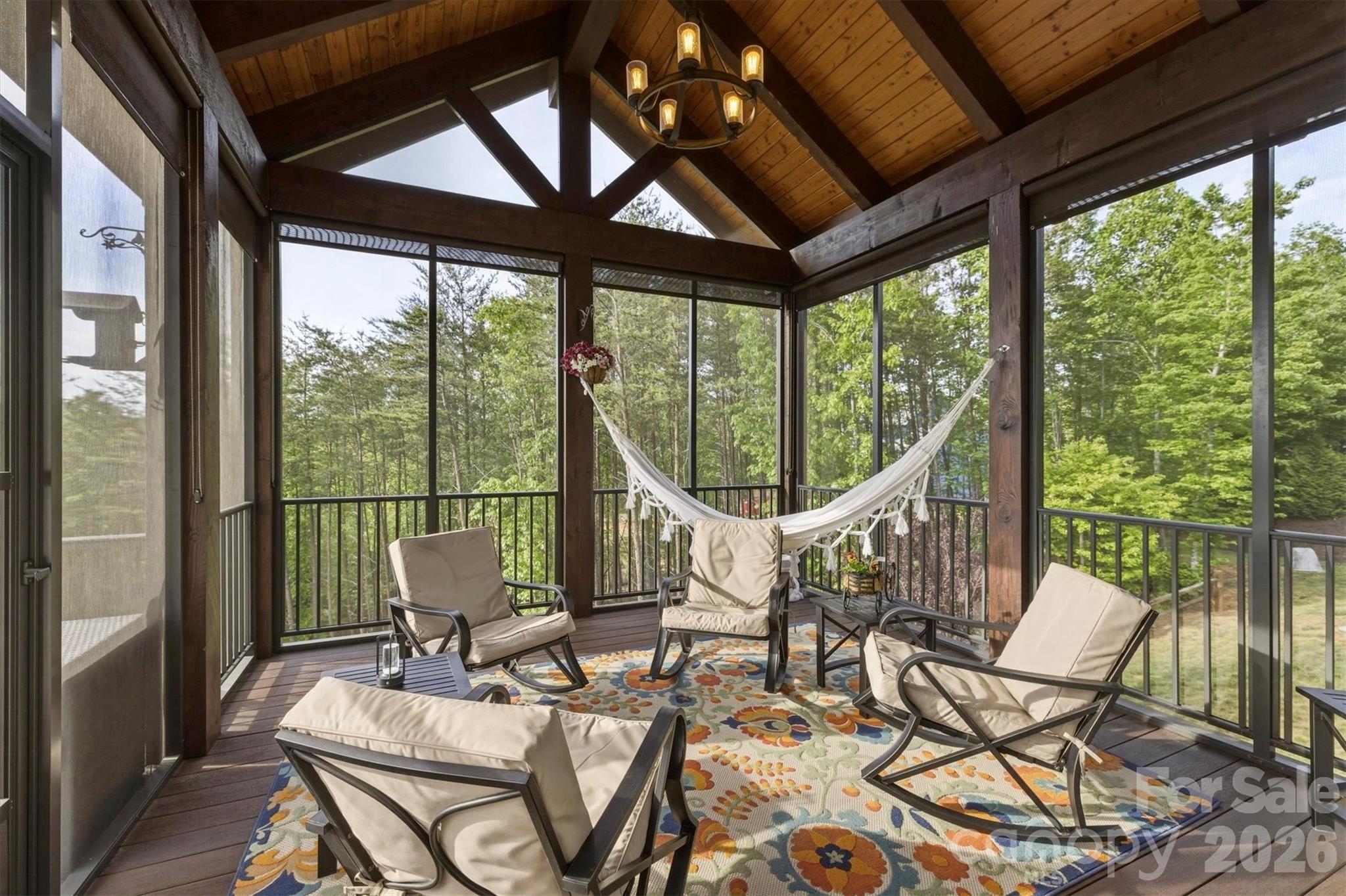 The screened in porch provides extra sitting area for enjoying family and friends. Top of the line shades can be left in the up position for views or rolled down to give extra privacy and/or block the afternoon sun. Ideal for outside television viewing! - 1506 High Valley Way, Lenoir
