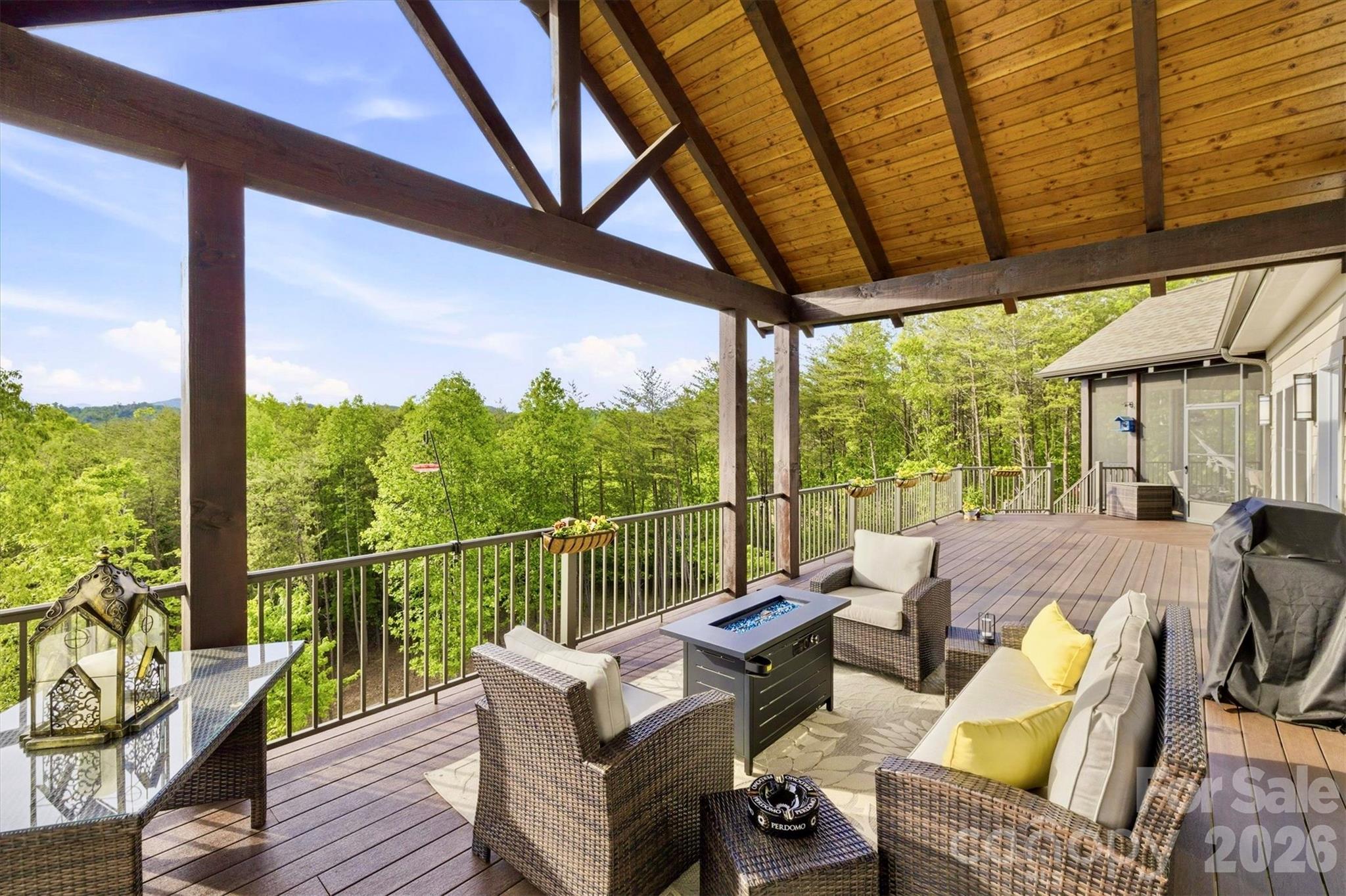 Experience seamless indoor-outdoor living and more highland panorama from the expansive, 14 ft deep, main level open air deck, screened porch, and covered porch. The porches' vaulted tongue-and-groove wood ceilings, durable Fiberon composite flooring, and commanding structural beams elevate the spaces and ensure 4 season enjoyment. - 1506 High Valley Way, Lenoir