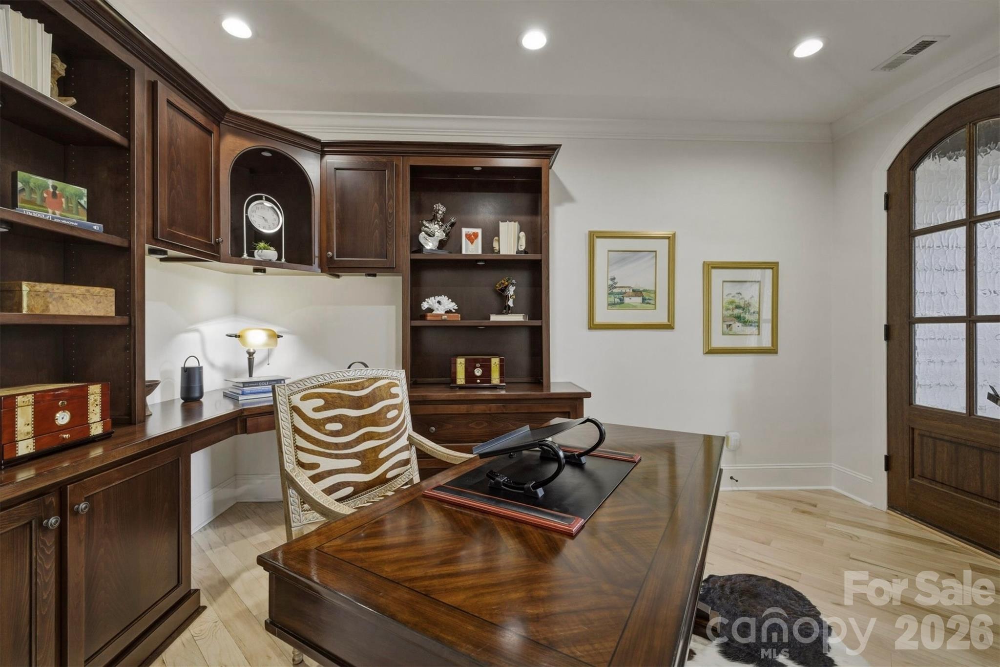 Create a personal library or home office in the private study. White walls highlight the dark lustre of custom built wood bookcases and furniture, creating a sophisticated academic aesthetic. Off to itself by the garage, the study has two entrances, one from an interior hallway and a dedicated separate entry/exit at the end of the front porch. - 1506 High Valley Way, Lenoir
