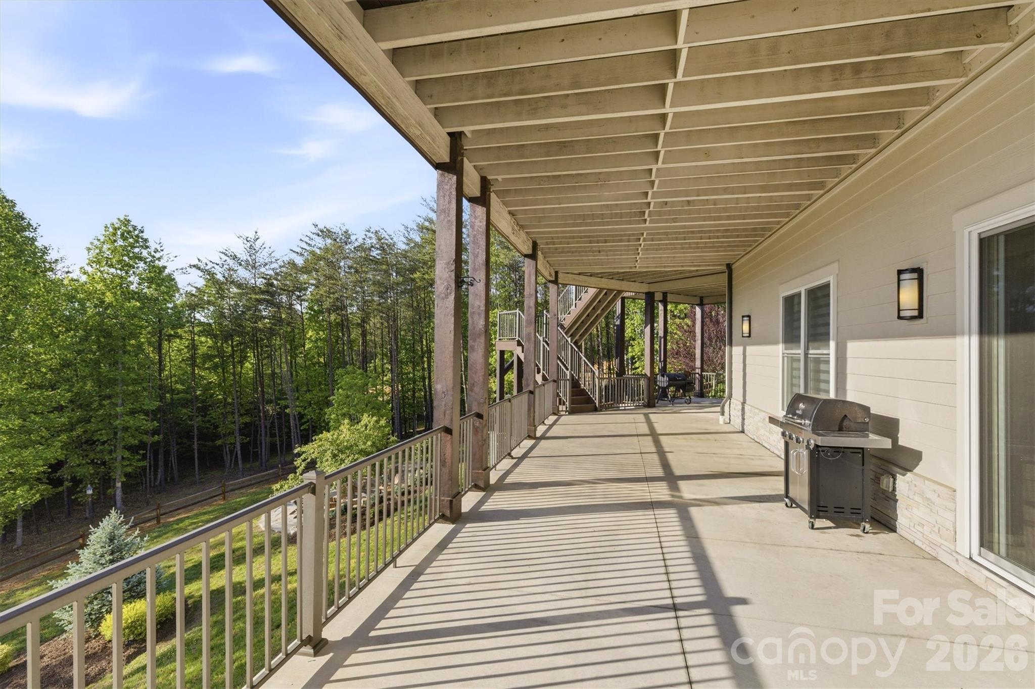 The deep concrete lower level porch spans the back of the house offering a versatile footprint for an outdoor lounge, alfresco dining, a private hot tub retreat, and more. A propane gas line is run to this area, ready to hook up a grill, gas fire pit, or hot tub - 1506 High Valley Way, Lenoir