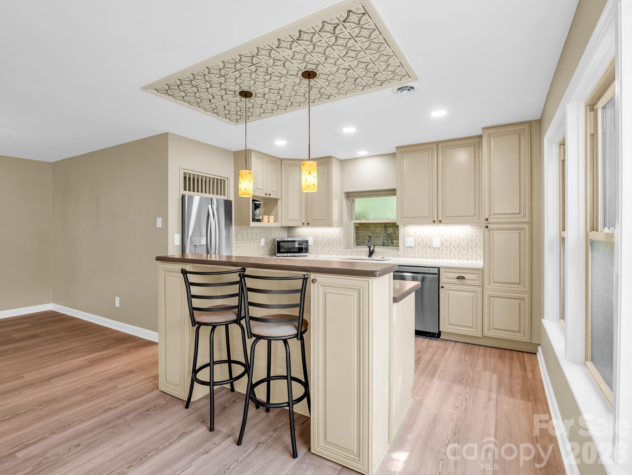 The breakfast bar and island with a custom tin design overhead. - 44 Jervey Road, Tryon