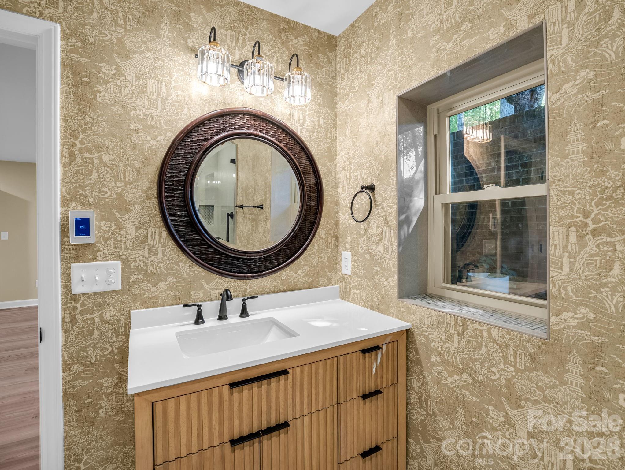 The primary bath was completely renovated with a new vanity, wallpaper, heated tile floor , and tile shower. - 44 Jervey Road, Tryon