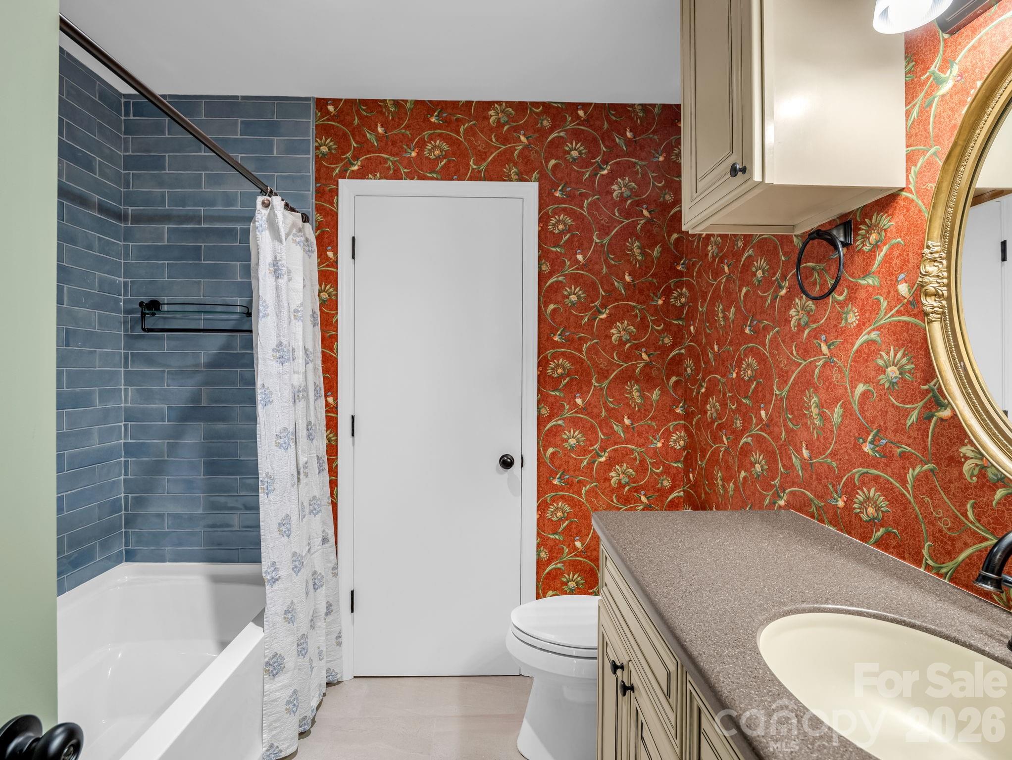 Guest bathroom in the hall between the primary bedroom and office with a new tub, tile floor and new fixtures. The door is to a large storage / linen closet. - 44 Jervey Road, Tryon