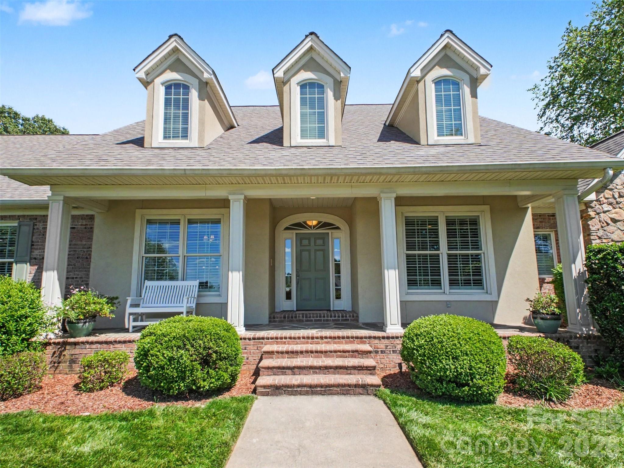 A large covered porch and pristine landscaping greet you. Sellers added landscape lighting for ambiance at night. - 1422 Stone Gate Drive, Shelby