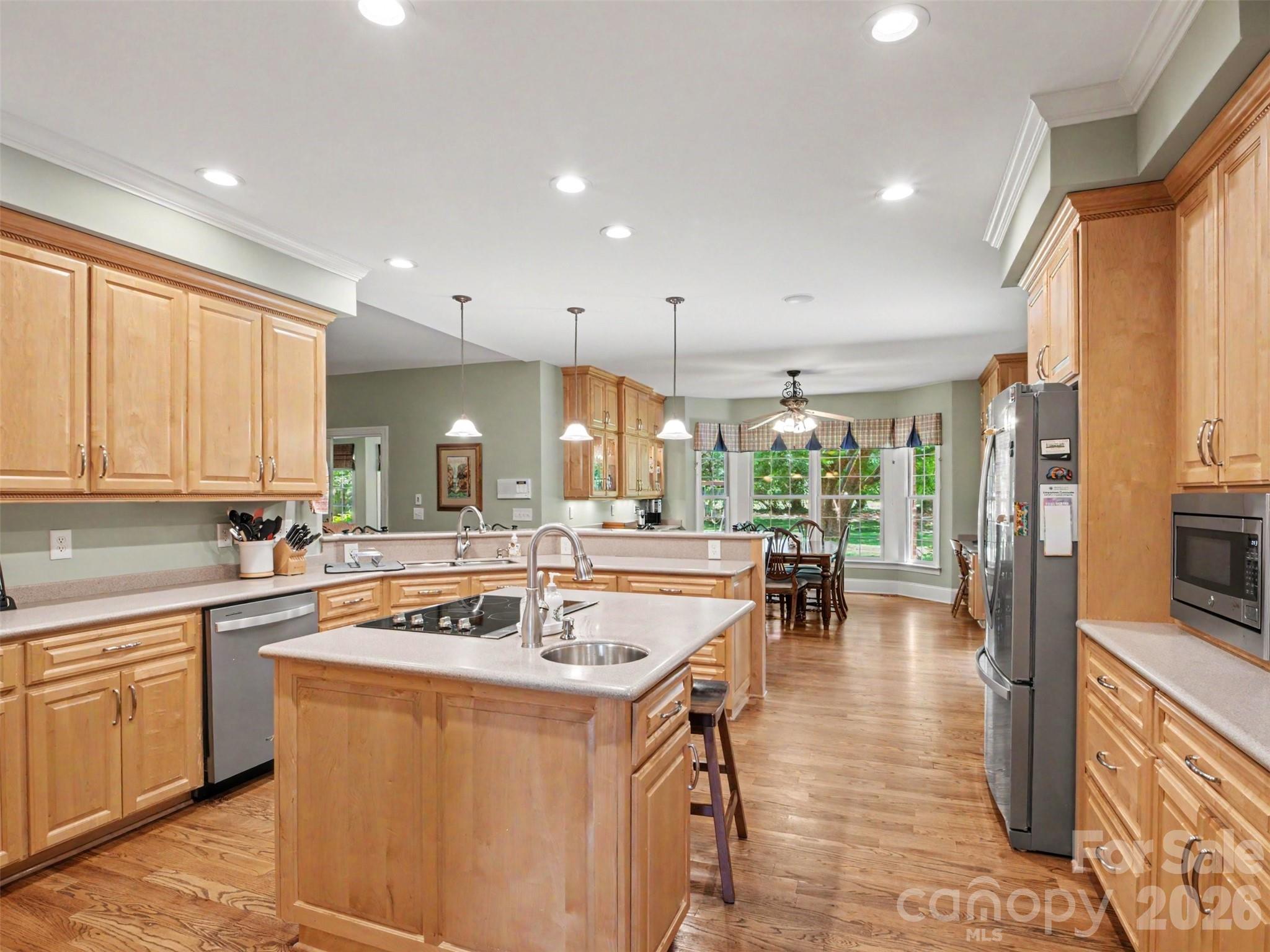 The open kitchen is in the middle of the home and features a center island with a built-in cooktop and prep sink,... - 1422 Stone Gate Drive, Shelby