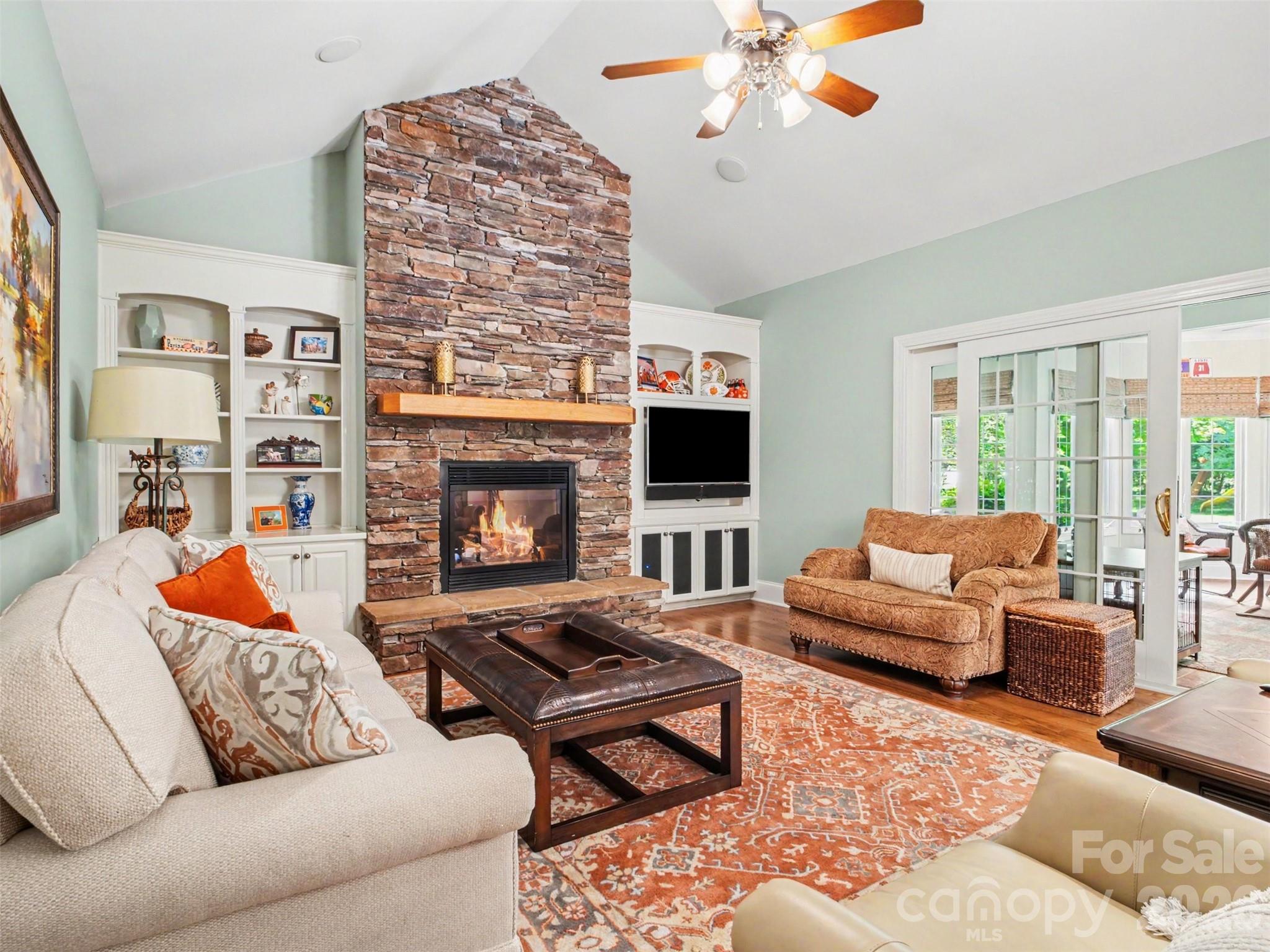 ...and stone gas fireplace focal point flanked by built-in shelves and cabinets. The television seen here conveys with the home. This fireplace has a remote and blower as well. - 1422 Stone Gate Drive, Shelby