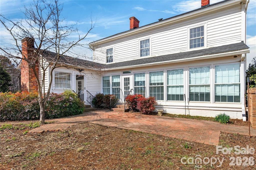Rear view of the home, showing the enclosed porch and kitchen wing addition - 11124 Eastfield Road, Huntersville