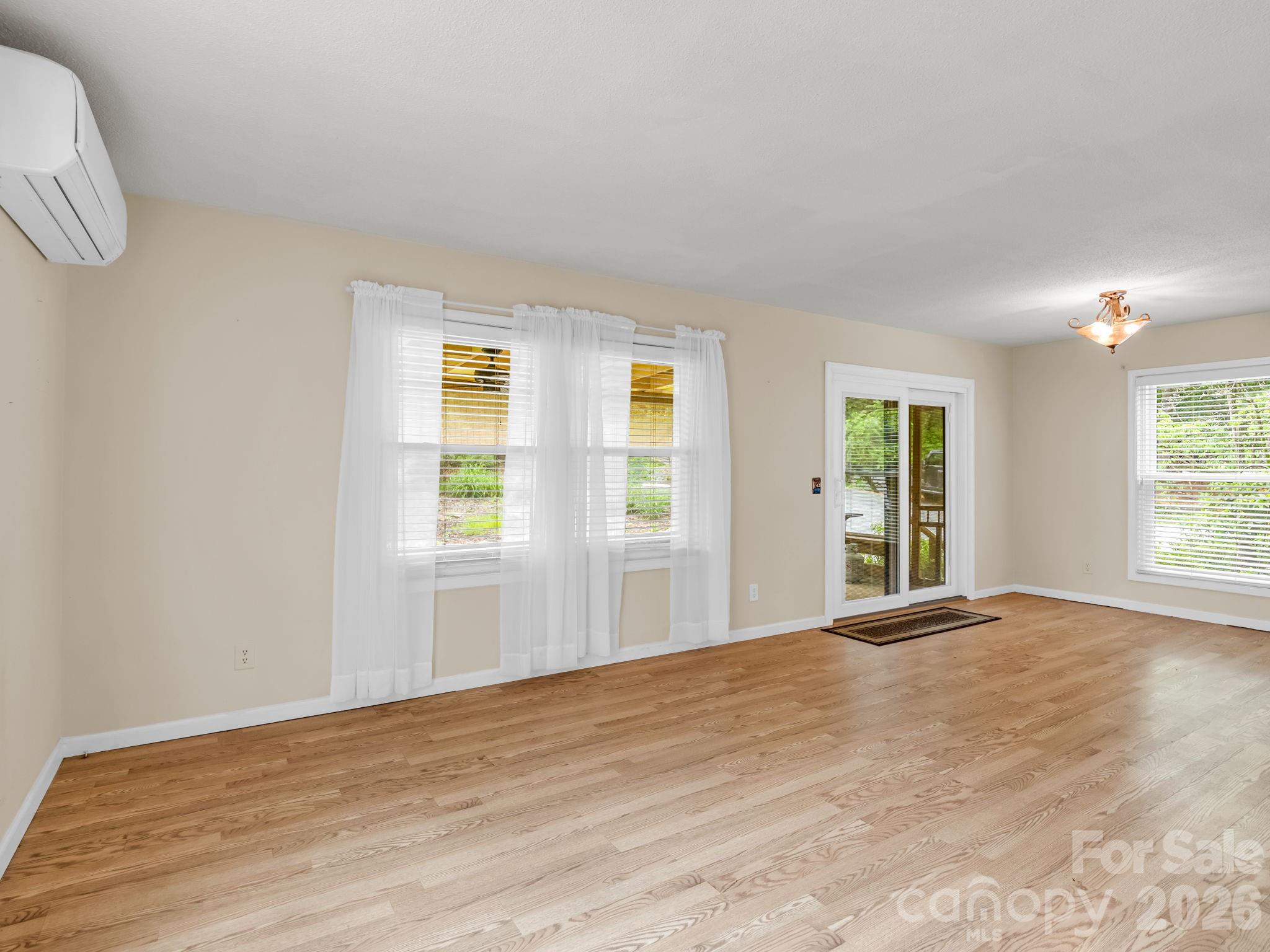 Living area on main level looking toward the sliding doors to screened in porch - 117 Willow Way, Hendersonville