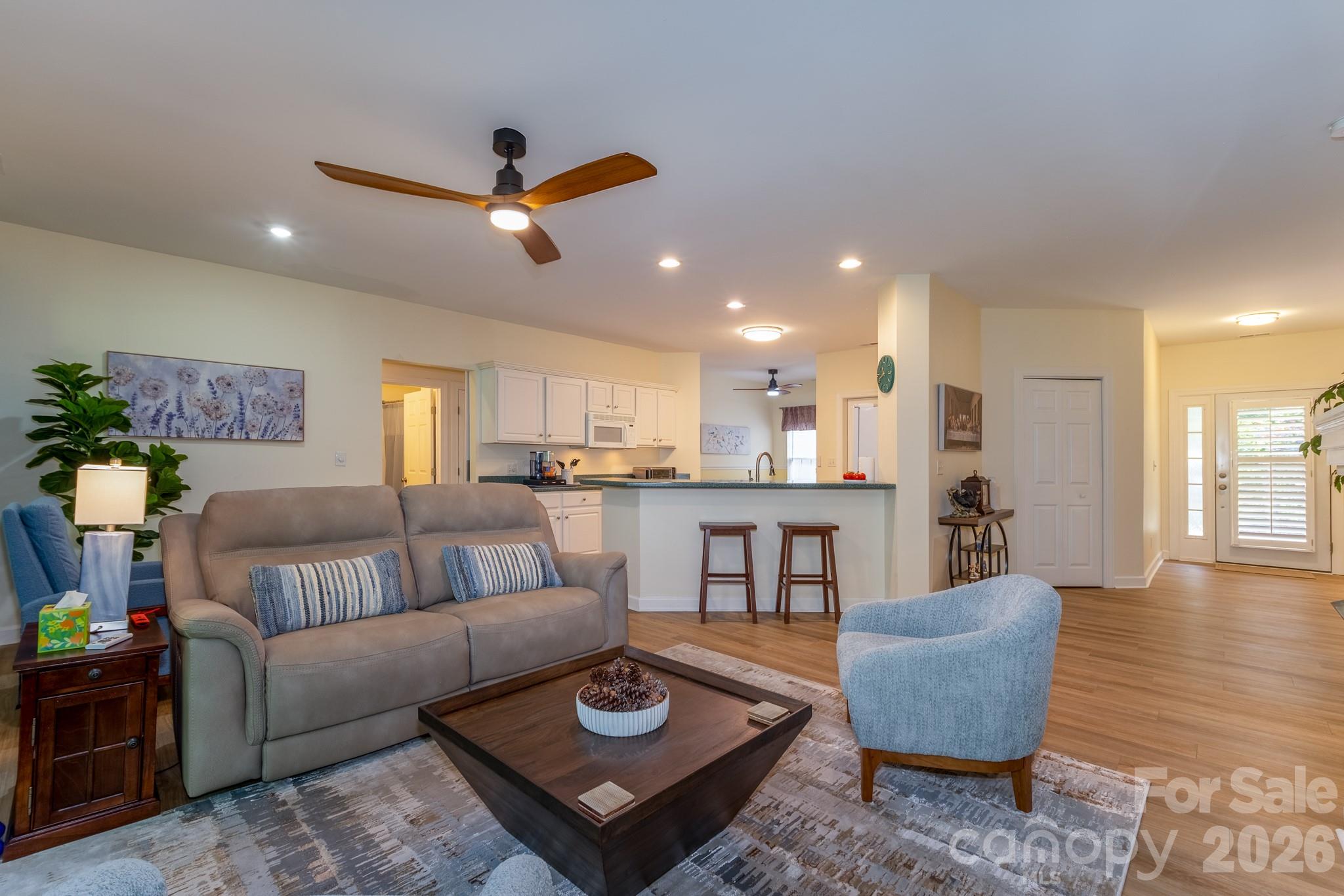 Spacious Open Floor Plan – Bright and open living room with updated flooring, modern ceiling fan, breakfast bar seating, and excellent flow for entertaining. - 99 Ridgetop Circle, Brevard