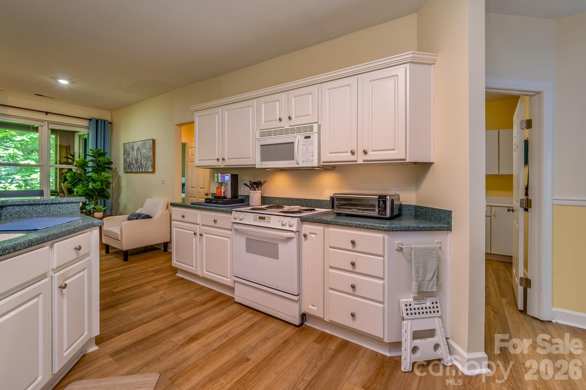 Kitchen with Abundant Storage – Large kitchen offering extensive cabinet space, generous countertops, and convenient access to the adjoining dining area. - 99 Ridgetop Circle, Brevard
