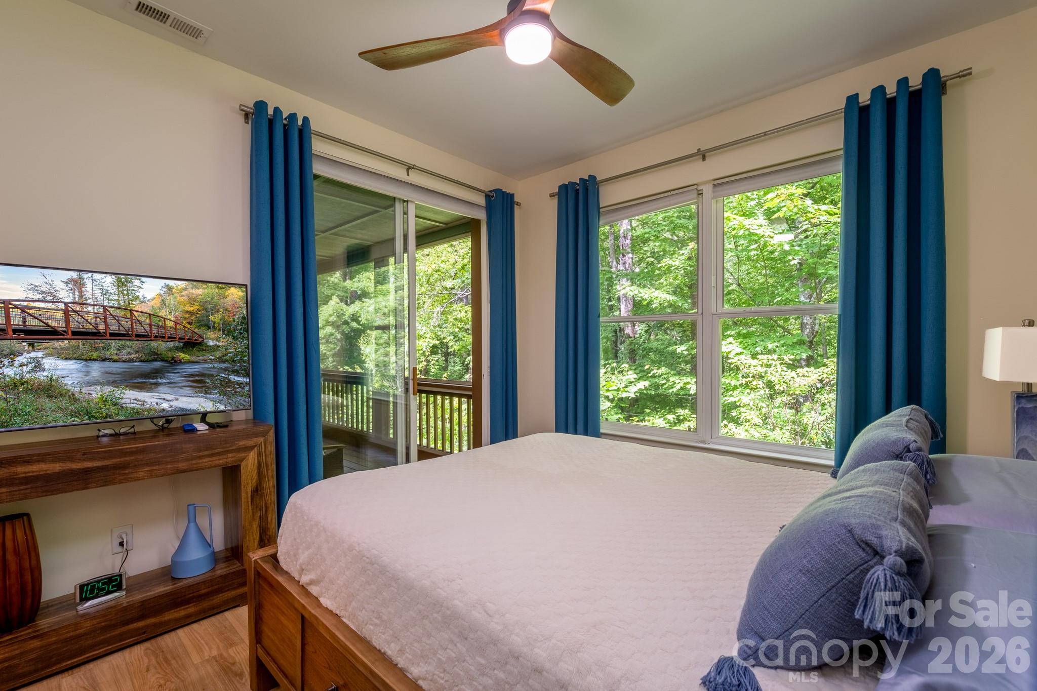 Guest Bedroom with Private Screened Porch Access – Comfortable secondary bedroom offering sliding door access to the screened porch, abundant natural light, and a relaxing connection to nature. - 99 Ridgetop Circle, Brevard