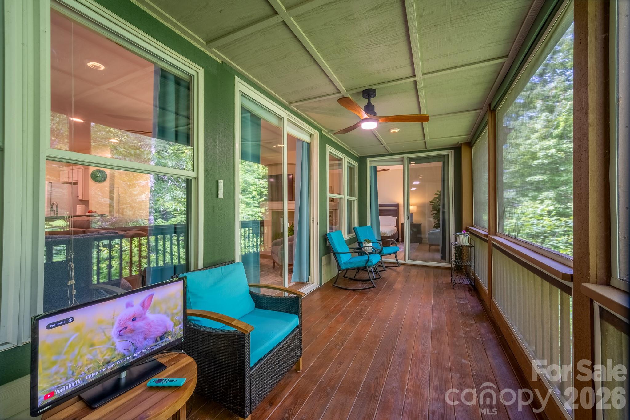 Screened Porch Overlooking Woods – Expansive screened porch perfect for outdoor living, featuring wooded privacy, ceiling fan, and multiple seating areas to enjoy the peaceful surroundings. - 99 Ridgetop Circle, Brevard
