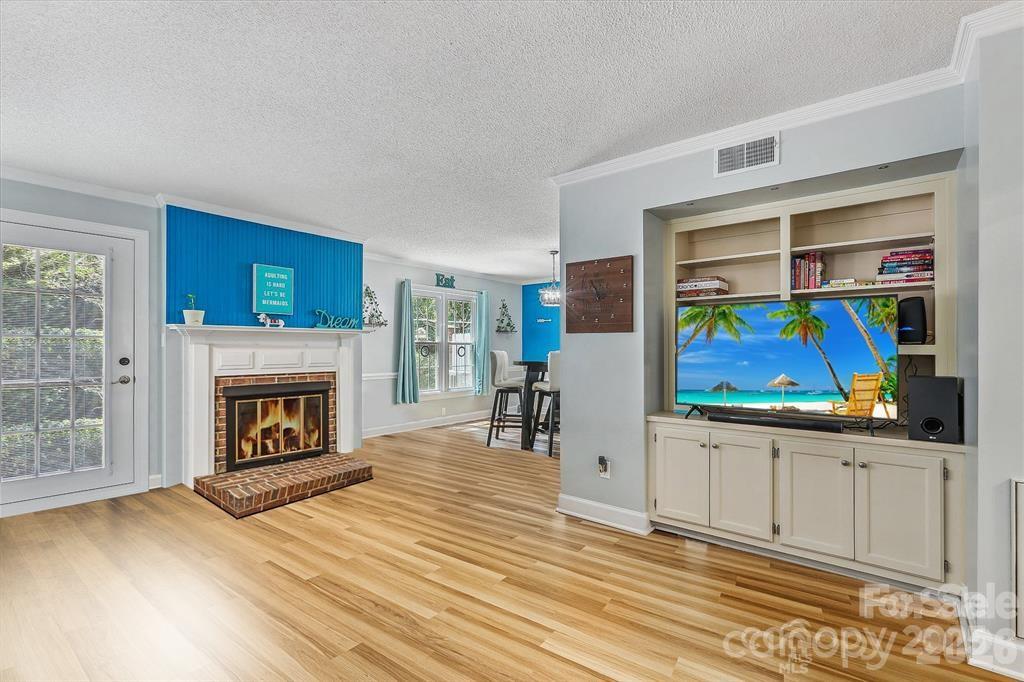 Warm and inviting living room featuring a cozy fireplace, custom built-in shelving, and plenty of space to relax or entertain. Natural light and timeless details create the perfect gathering place to call home - 806 Colony Oaks Drive, Monroe