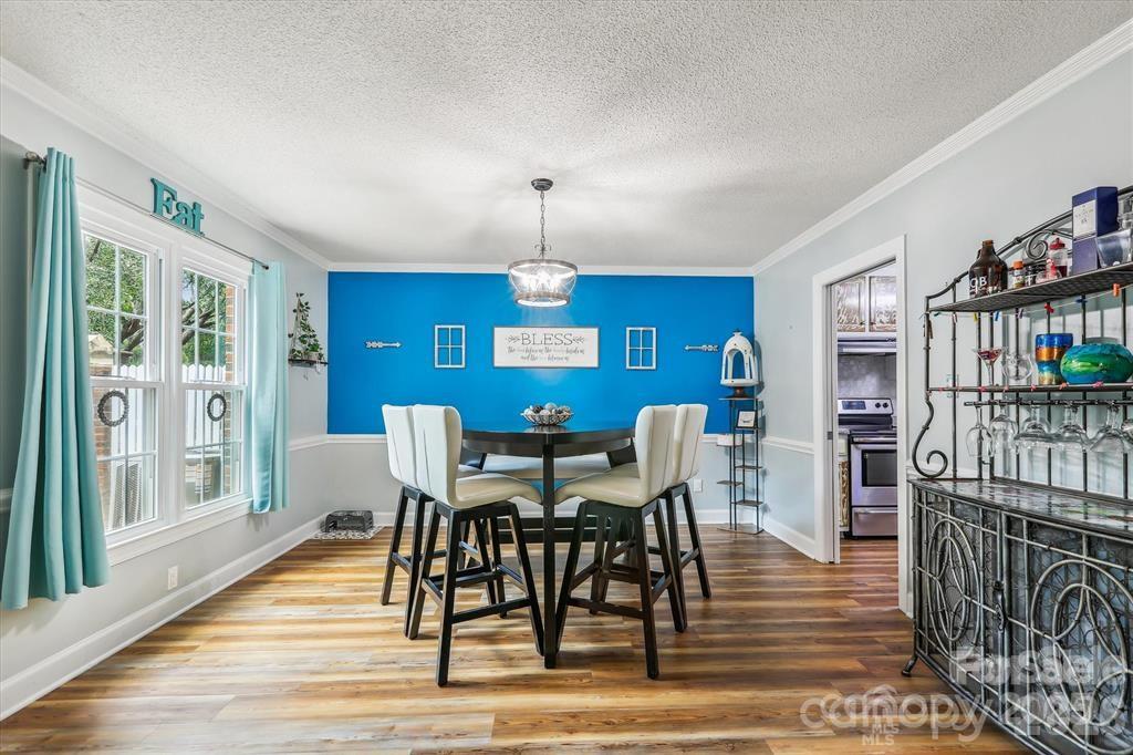 Large windows fill the dining room with abundant natural light, creating a bright and welcoming space throughout the day - 806 Colony Oaks Drive, Monroe