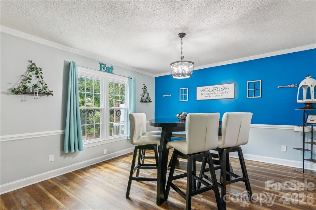 Overlooking the cozy fireplace, this inviting dining space offers warmth, character, and the perfect setting for memorable meals - 806 Colony Oaks Drive, Monroe