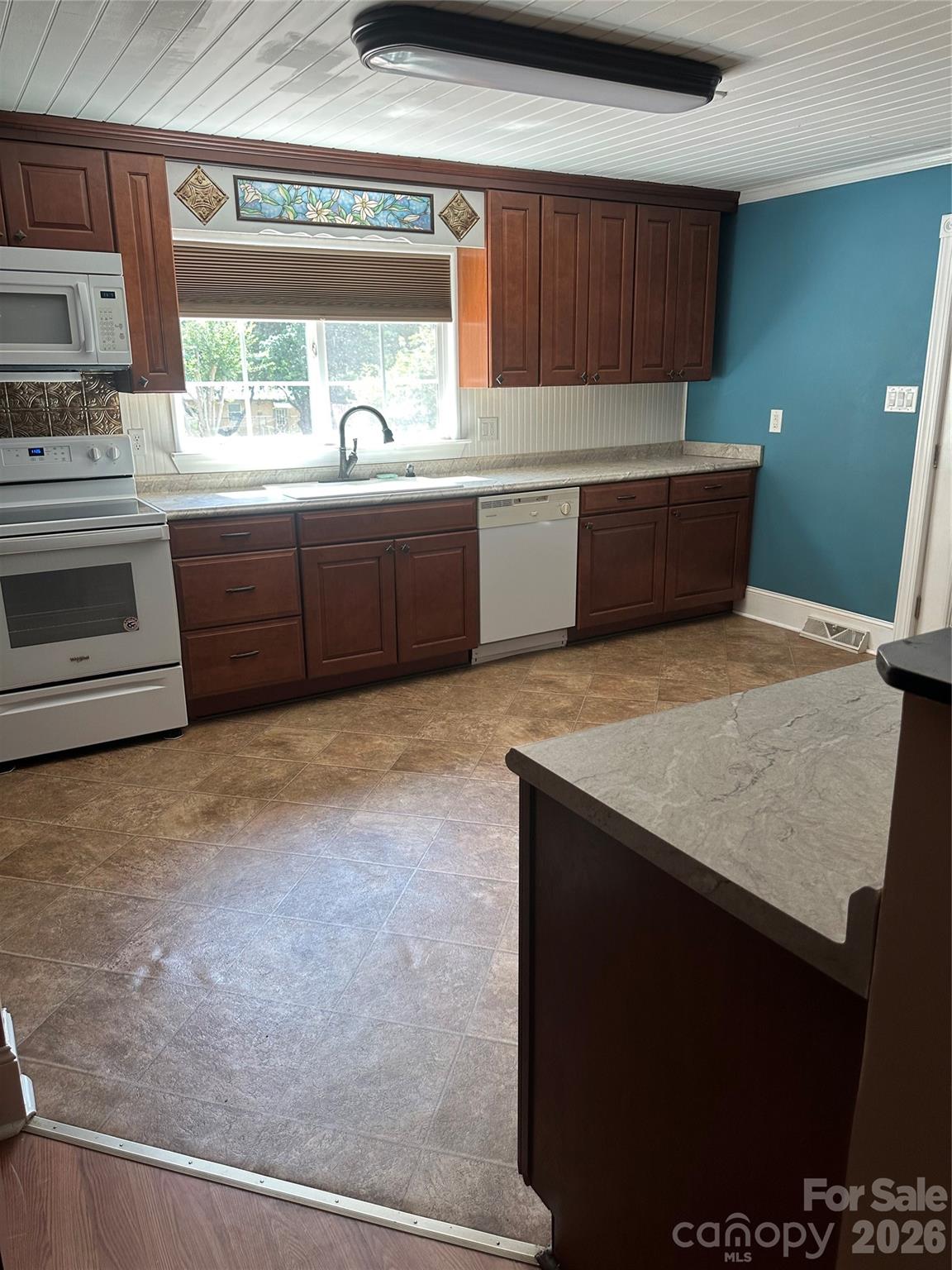 Kitchen, with a view of the stain glass above sink - 1407 N College Avenue, Newton