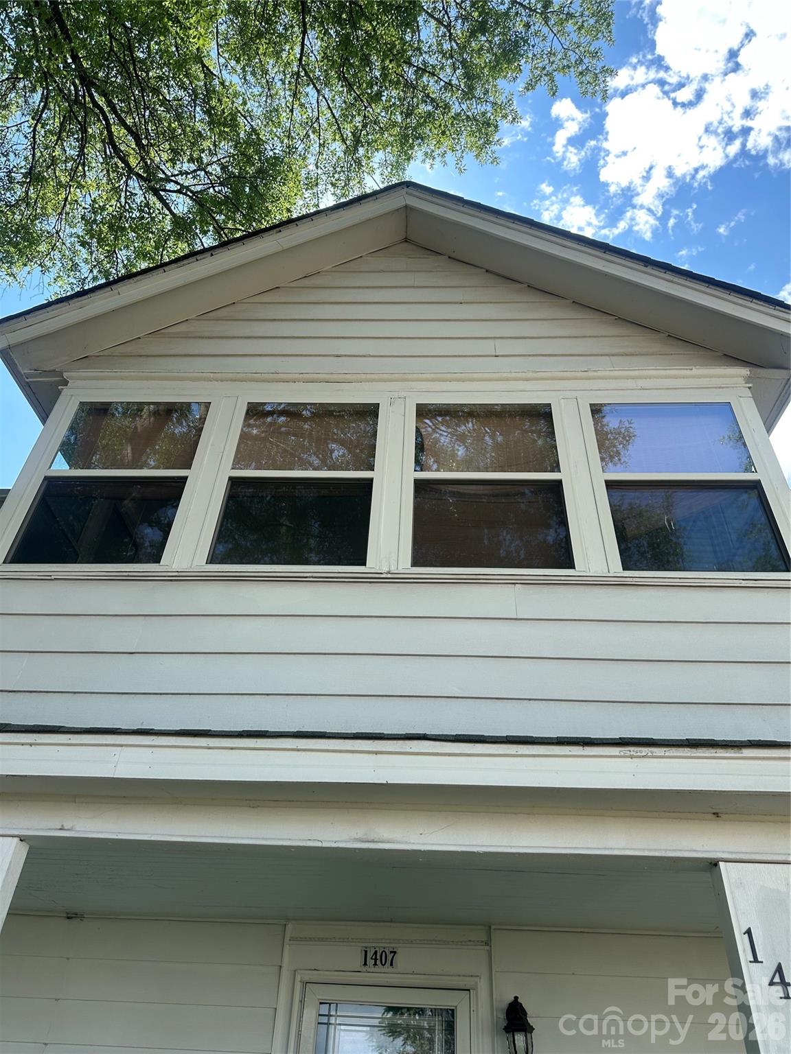 Looking up at the sunroom from outside. - 1407 N College Avenue, Newton