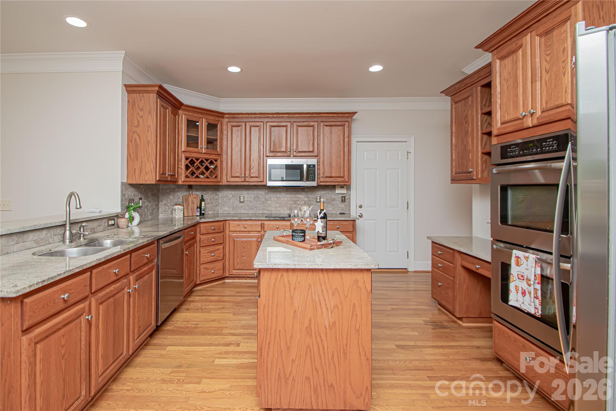 Kitchen has stainless steel appliances, double oven, granite countertops and gas stove. - 1015 Estate Lane, Matthews