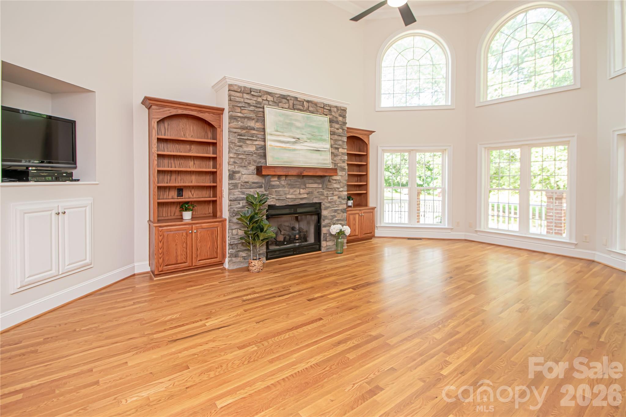 Great room has stone fireplace with bookcases at each side. - 1015 Estate Lane, Matthews