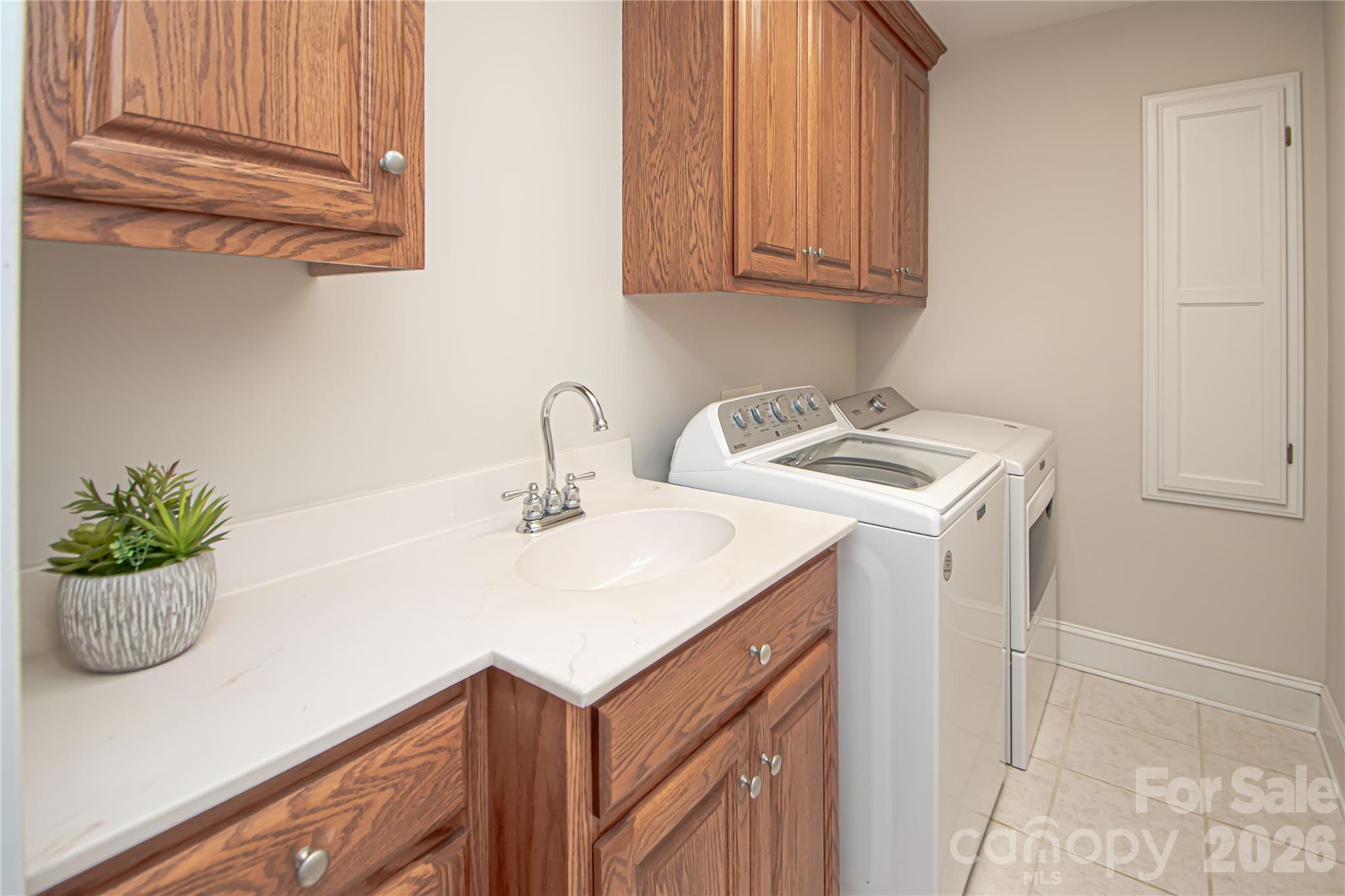 Laundry room is conveniently located on the second floor. It has a sink with plenty of cabinets. Washer and dryer convey. - 1015 Estate Lane, Matthews