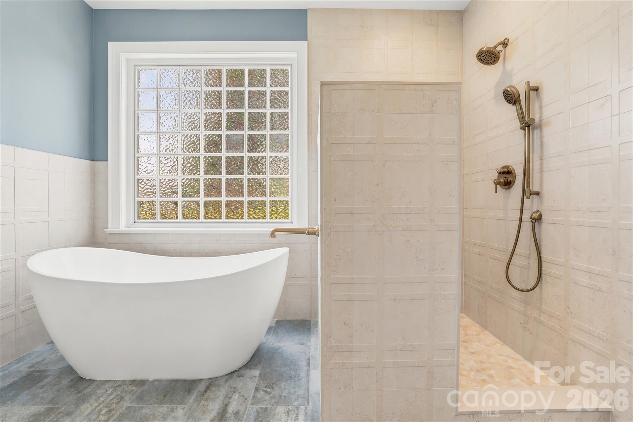 Renovated primary bath features a freestanding soaking tub and oversized walk-in shower. - 8520 Stock Horse Trail, Windsor