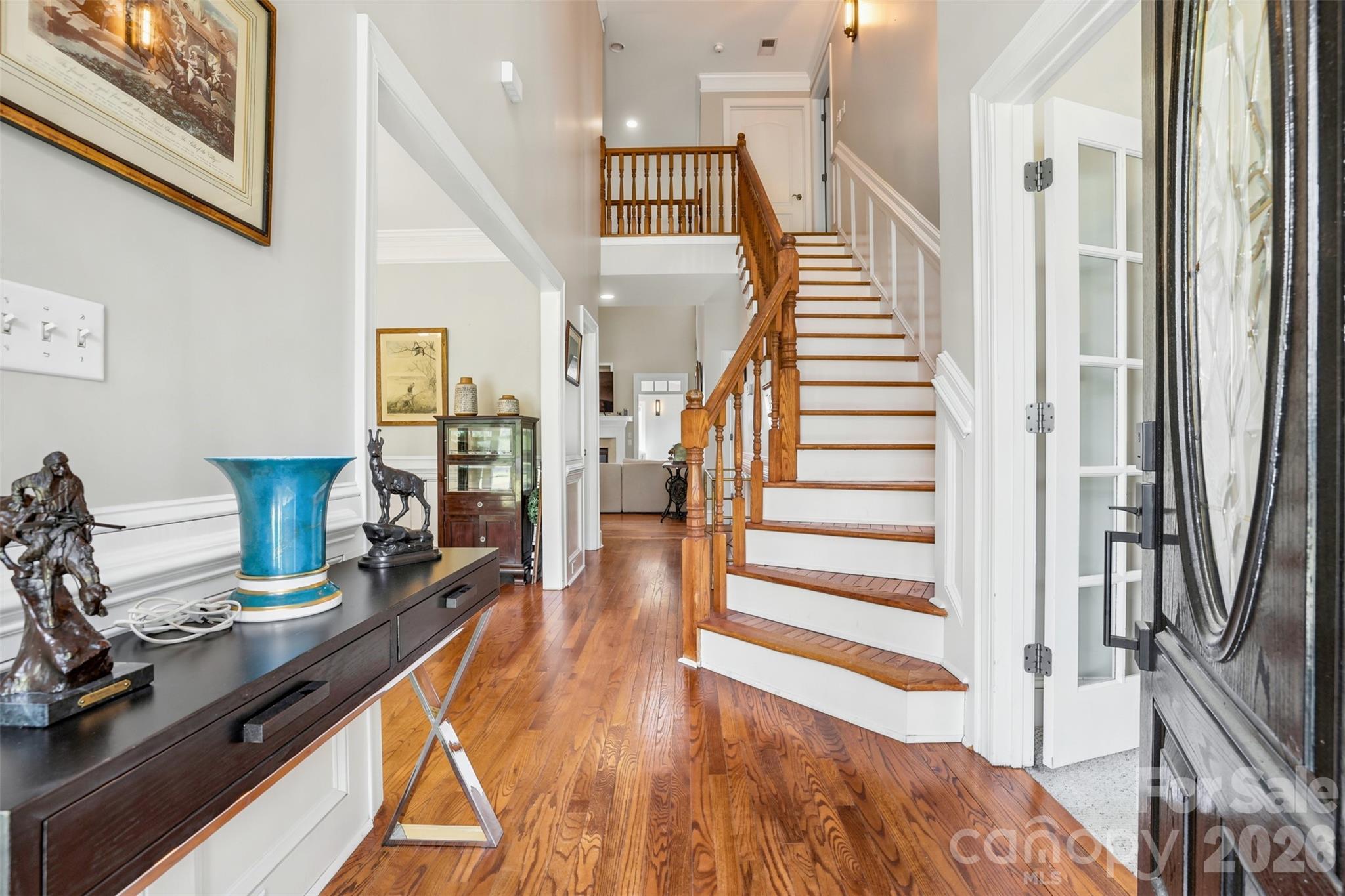 Grand foyer showcases hardwood floors, soaring ceilings, and a striking staircase. - 8520 Stock Horse Trail, Windsor