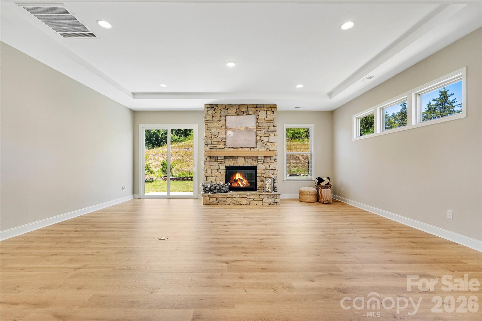 Living area with Tray Ceiling,NEW Flooring and NEW Pella Sliding Door (Virtually Staged Fire) - 8091 Woodline Lane, Denver