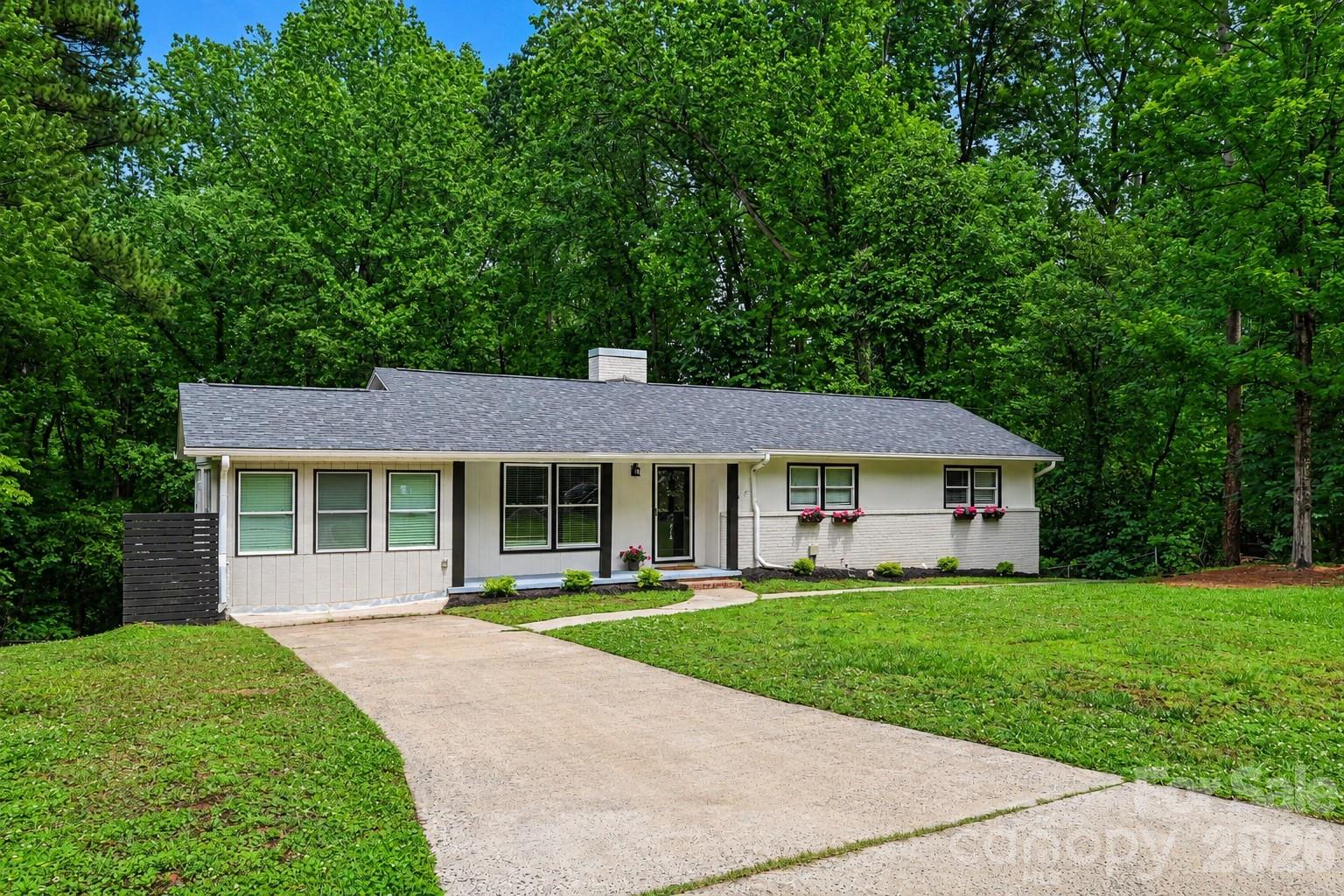 Fresh landscaping, mature trees, and a peaceful setting create a beautiful first impression. - 716 Grandview Drive NE, Concord