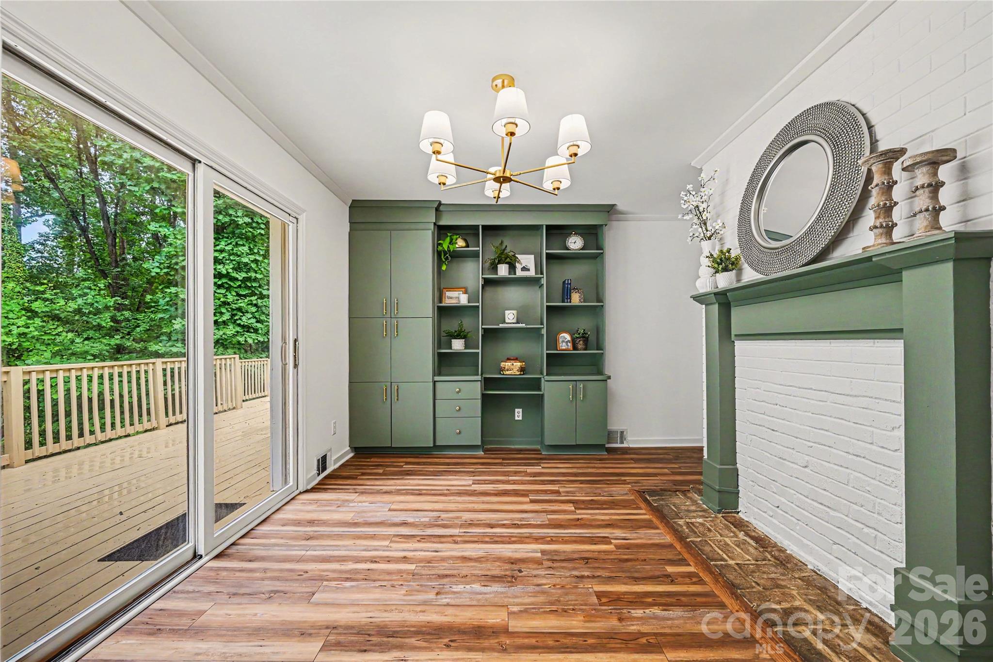 Dining area features custom built in storage and display shelving, a decorative fireplace, and direct access to the expansive deck. - 716 Grandview Drive NE, Concord