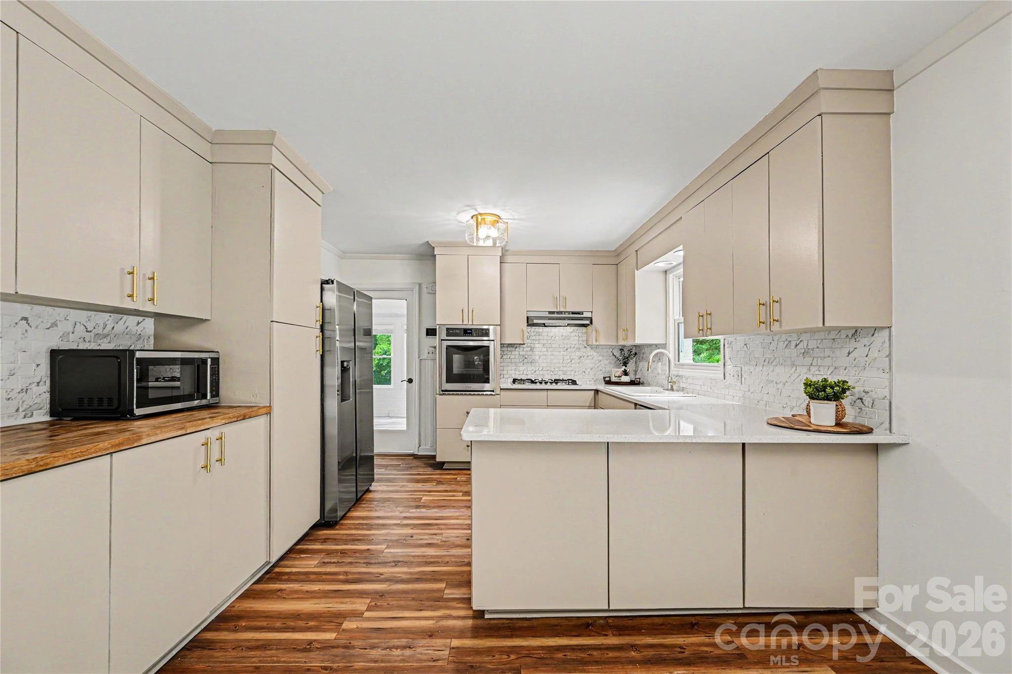 Spacious kitchen with oversized peninsula seating, extensive cabinet storage, and newer appliances. - 716 Grandview Drive NE, Concord