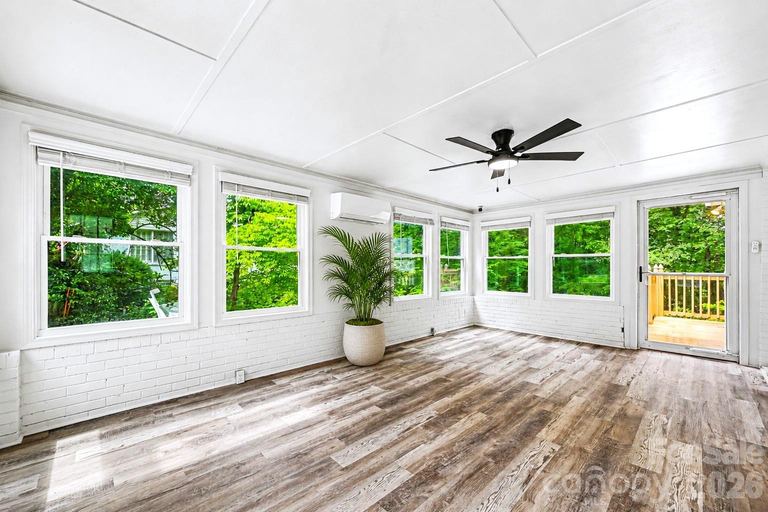 Light filled sunroom with its own mini split system, offering a comfortable space to relax, work, or entertain year round. - 716 Grandview Drive NE, Concord