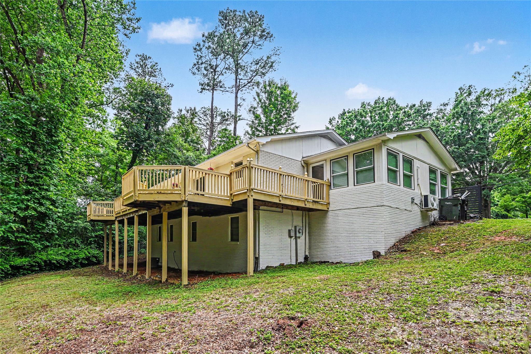 Private backyard setting with mature trees, a storage building, and over 600 square feet of deck space to enjoy it all. - 716 Grandview Drive NE, Concord