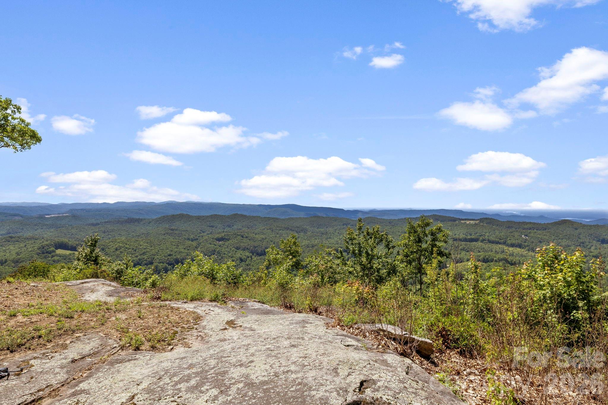 Expansive layered mountain views stretch across the horizon from this elevated vantage point, creating a stunning natural backdrop. - 9999 Rocky Mountain Road, Lake Toxaway