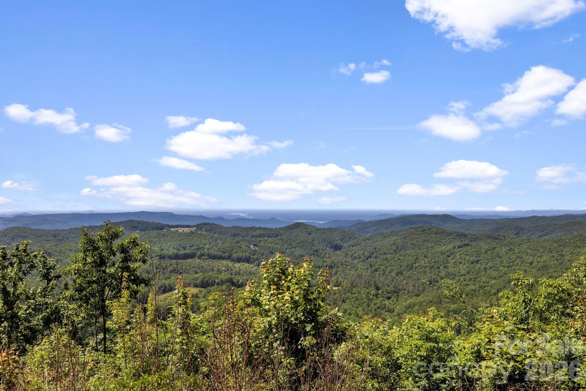 Enjoy sweeping views of rolling hills and forested ridgelines, showcasing the property's exceptional mountain setting. - 9999 Rocky Mountain Road, Lake Toxaway