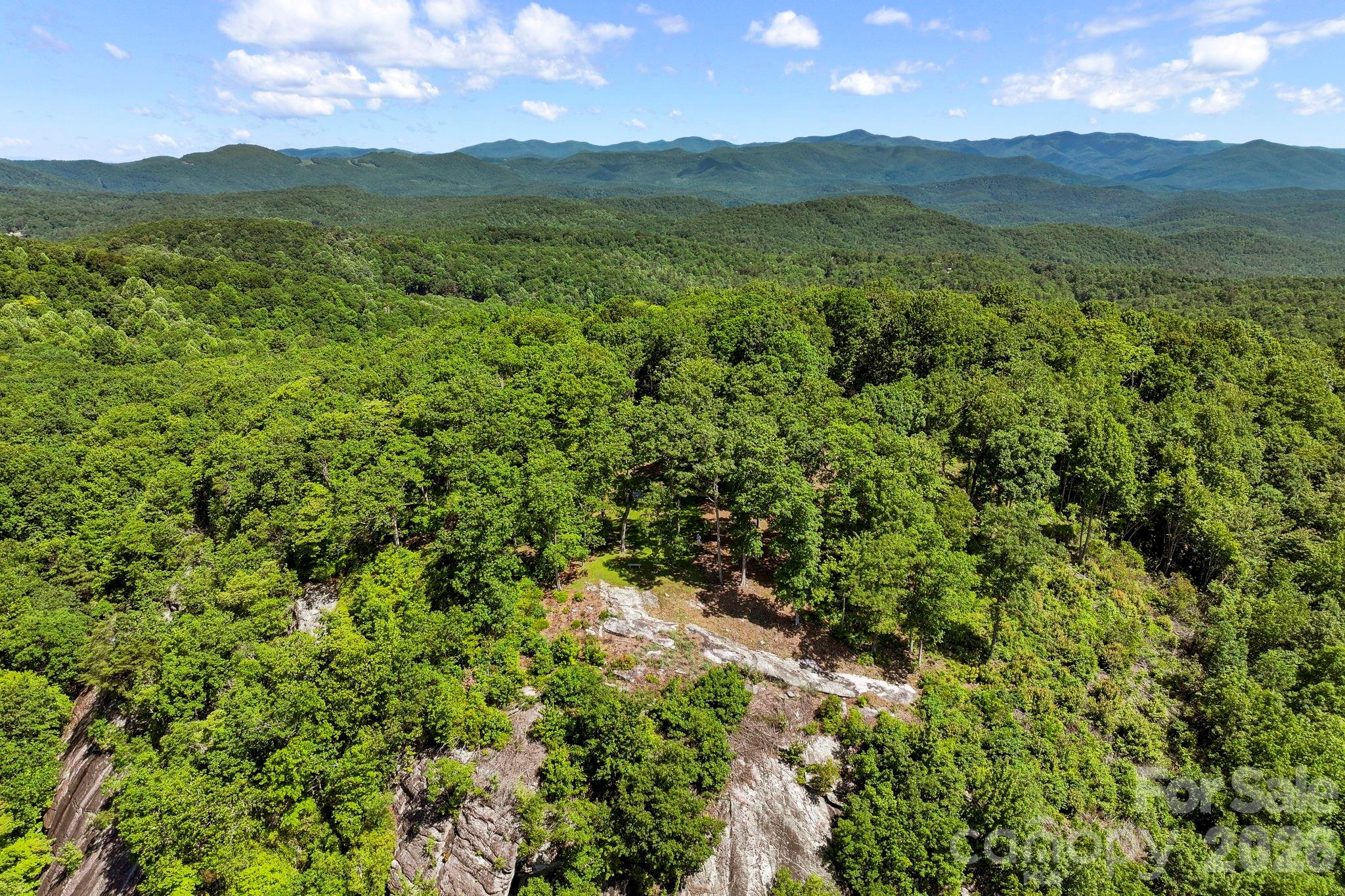 Drone imagery captures the homesite's impressive location overlooking layered mountain ranges and pristine natural landscapes. - 9999 Rocky Mountain Road, Lake Toxaway